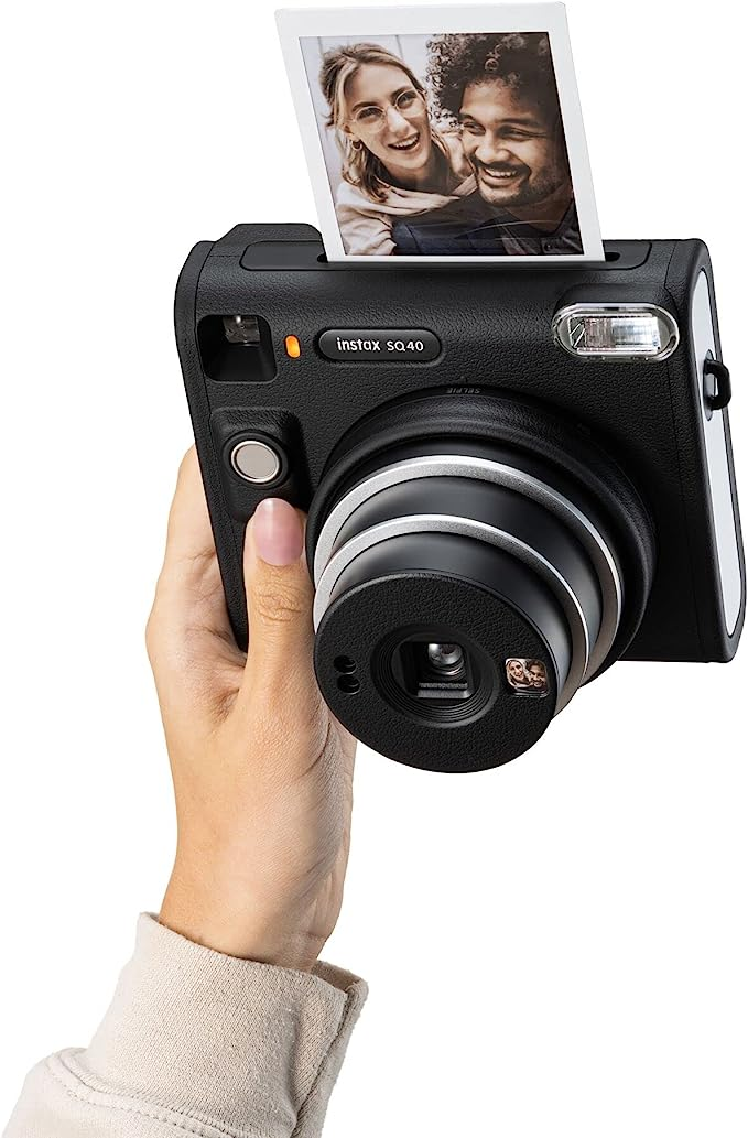Una persona sosteniendo una cámara Instax SQ40 negra.