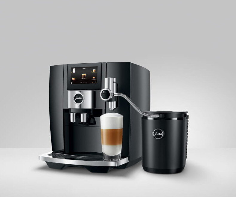 Czarny ekspres do kawy ze szklanką latte. Spieniacz do mleka jest z boku.