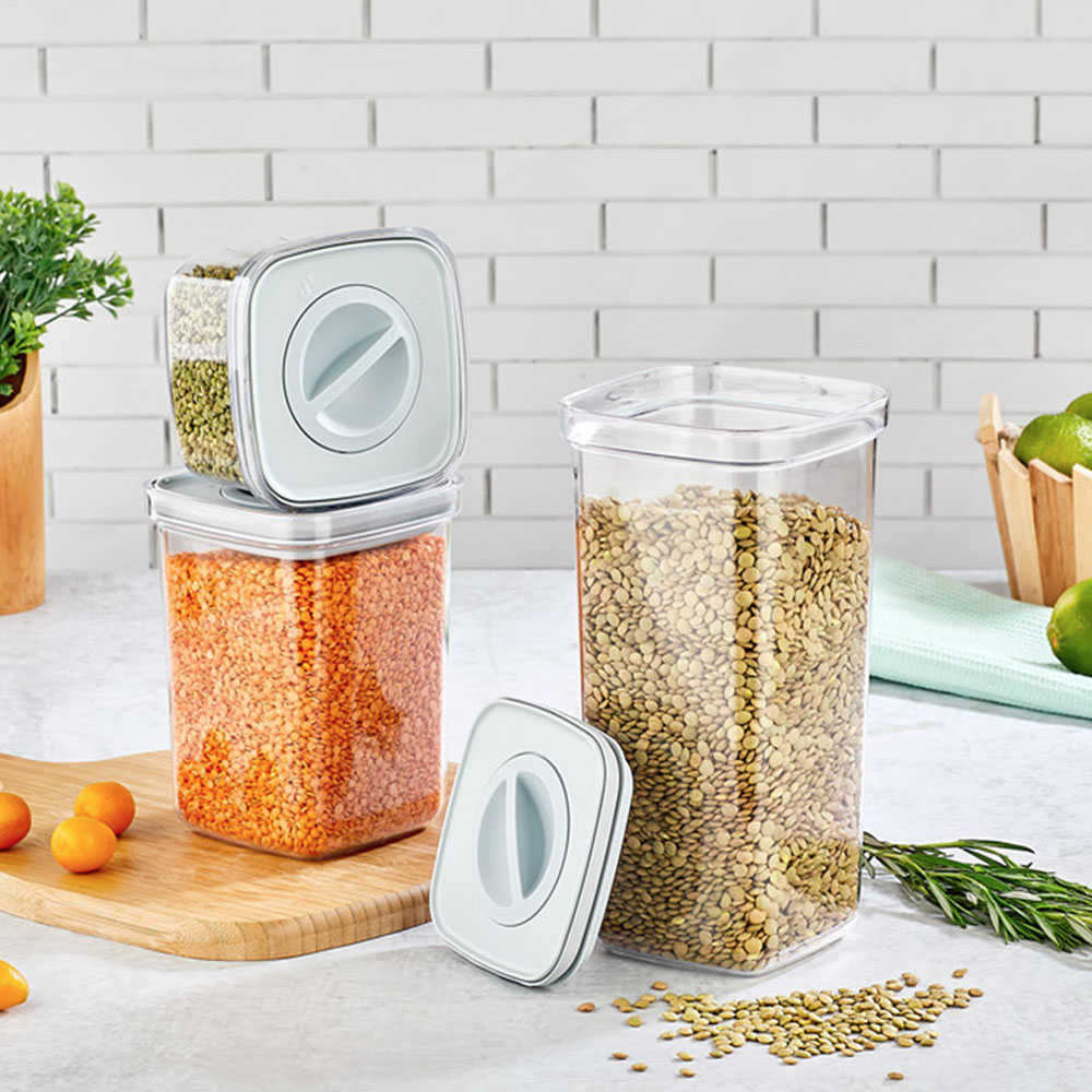 Mercimek ve tahıllarla dolu şeffaf kaplar. Turuncu mercimek ve limonlarla dolu bir kesme tahtası.