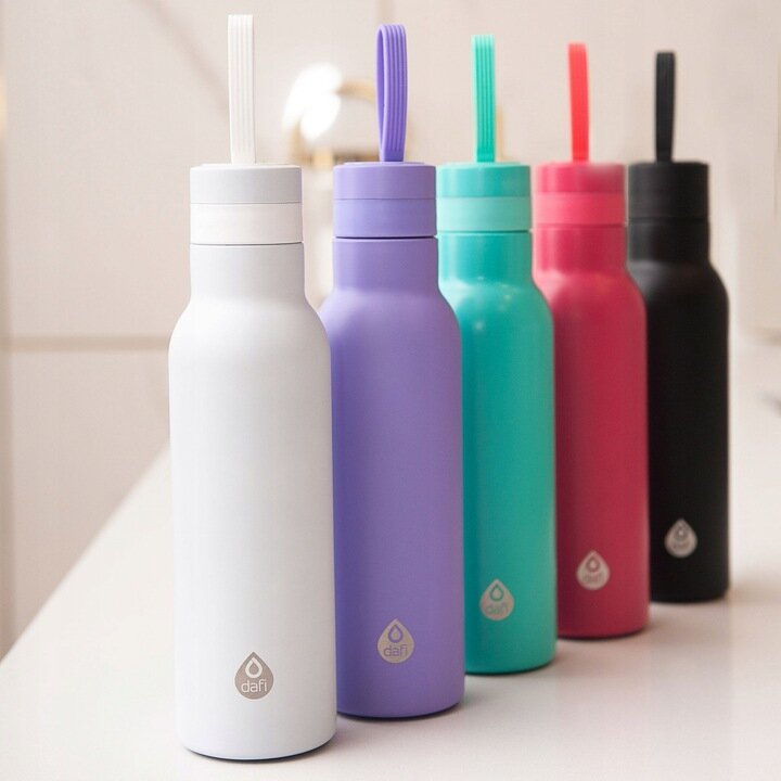 Pięć butelek Dafi w kolorach białym, fioletowym, turkusowym, różowym i czarnym stoi obok siebie.