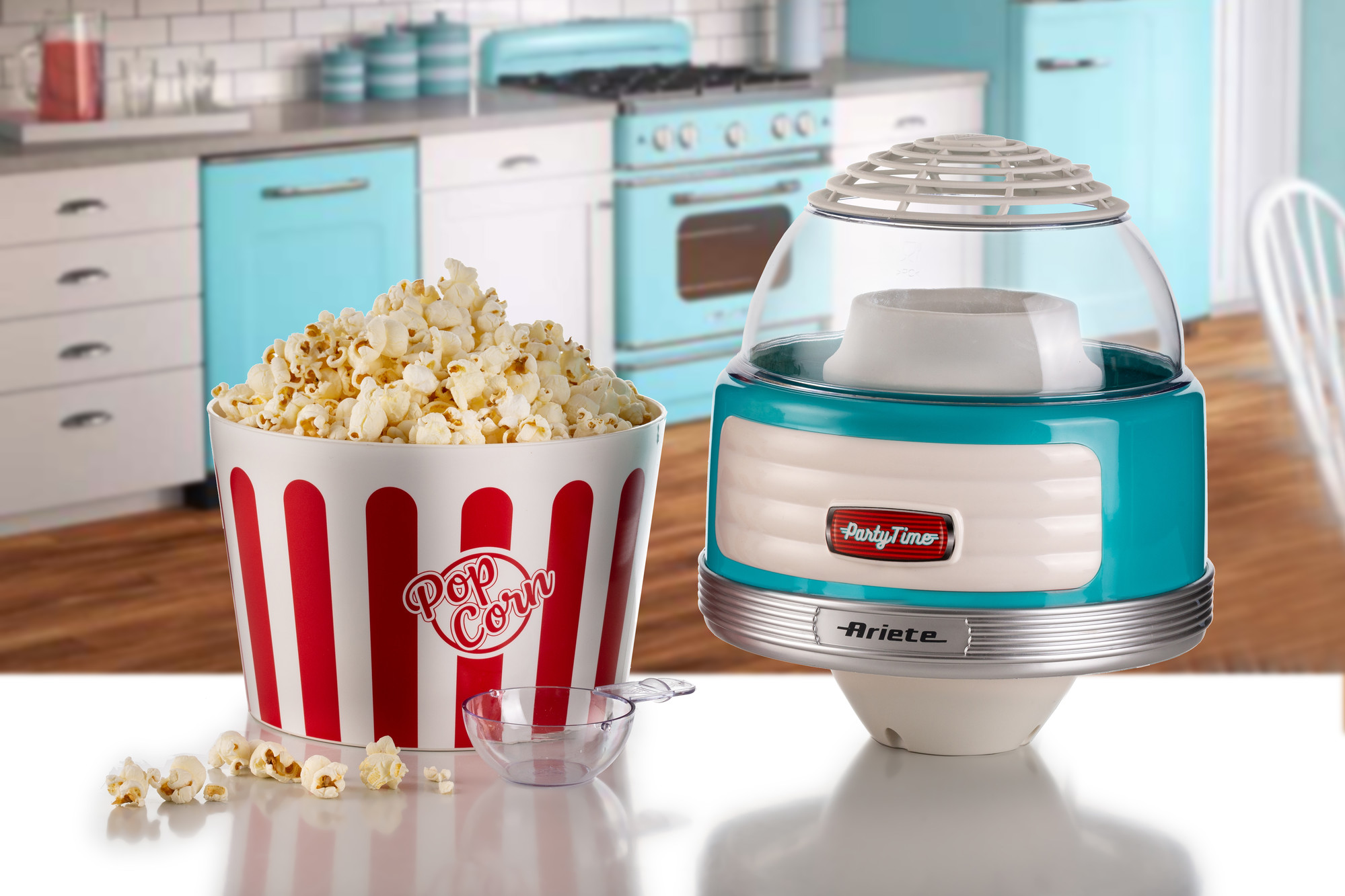 Popcornkészítő és egy tele popcornos vödör. Konyhai jelenet kék-fehér dekorációval.