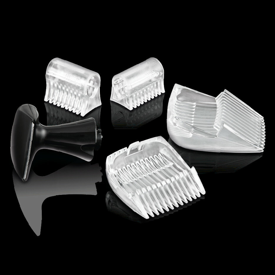 Kilka przezroczystych plastikowych nakładek do maszynki i czarny uchwyt. Ułożone na czarnej powierzchni.