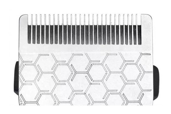 Zbliżenie srebrnej głowicy golarki z wzorem plastra miodu. Widoczne ostrza.