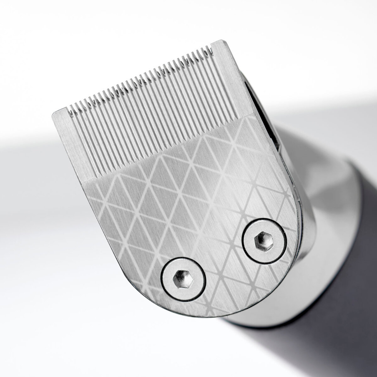 Zbliżenie srebrnego ostrza maszynki do włosów z dwiema śrubami.