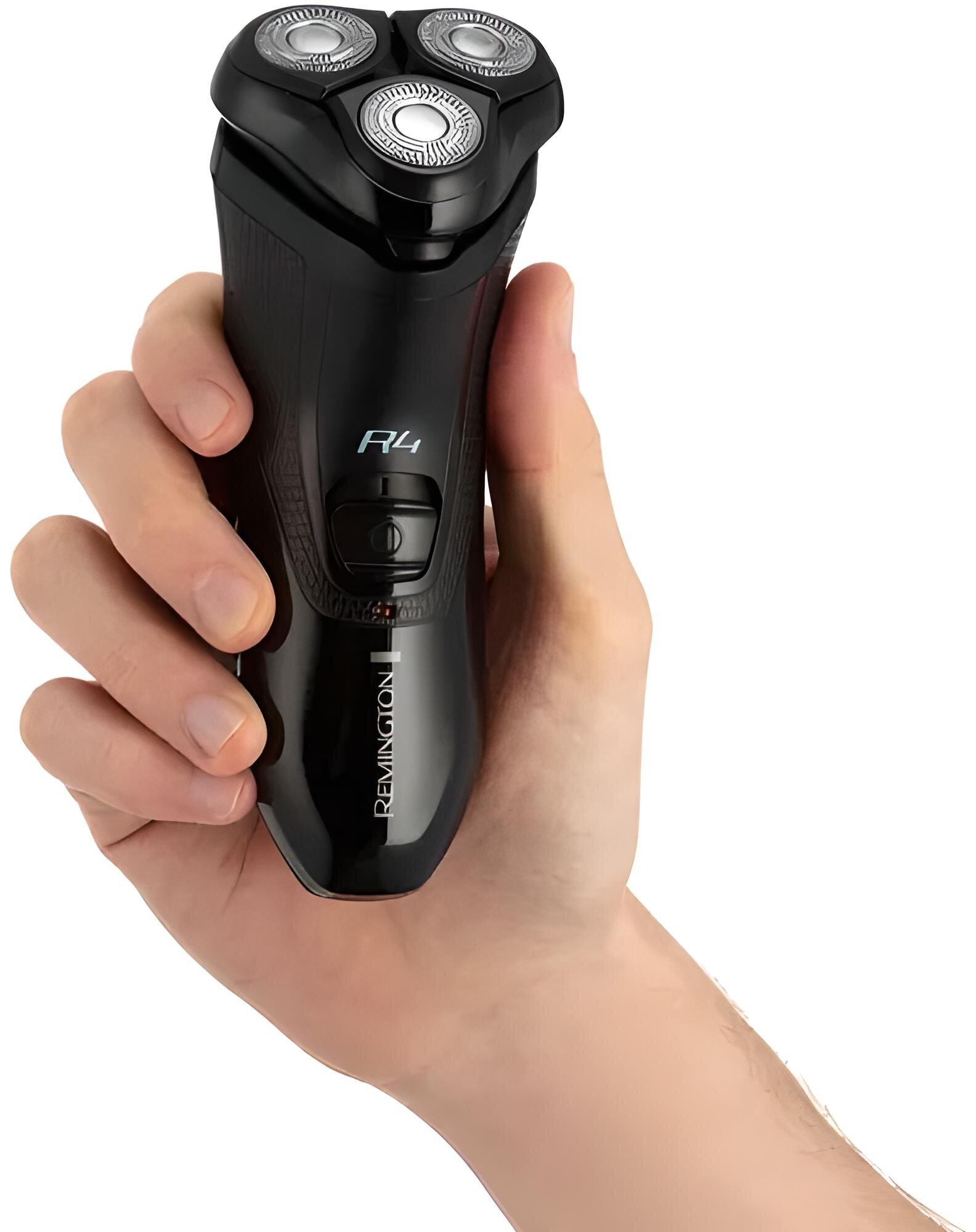 Ręka trzyma czarną golarkę Remington R4. Golarka ma trzy okrągłe głowice golące.