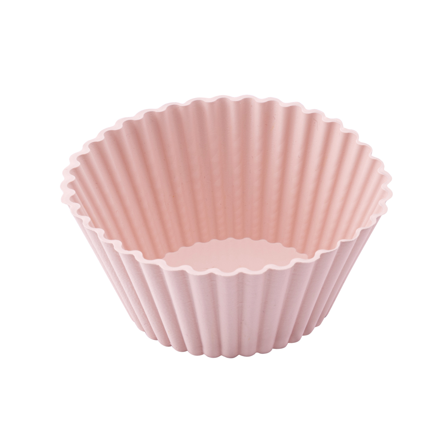Beyaz arka plan üzerinde izole edilmiş pembe, oluklu silikon kek kalıbı.