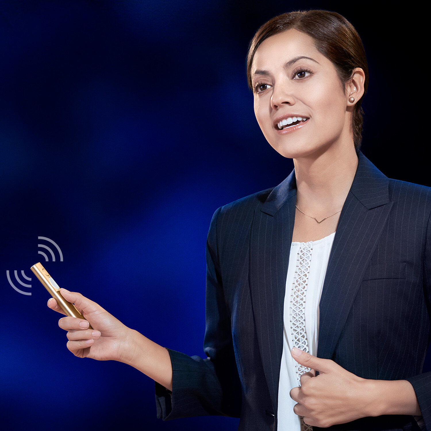 Kobieta trzymająca pilot do prezentacji, uśmiechnięta, na ciemnoniebieskim tle.