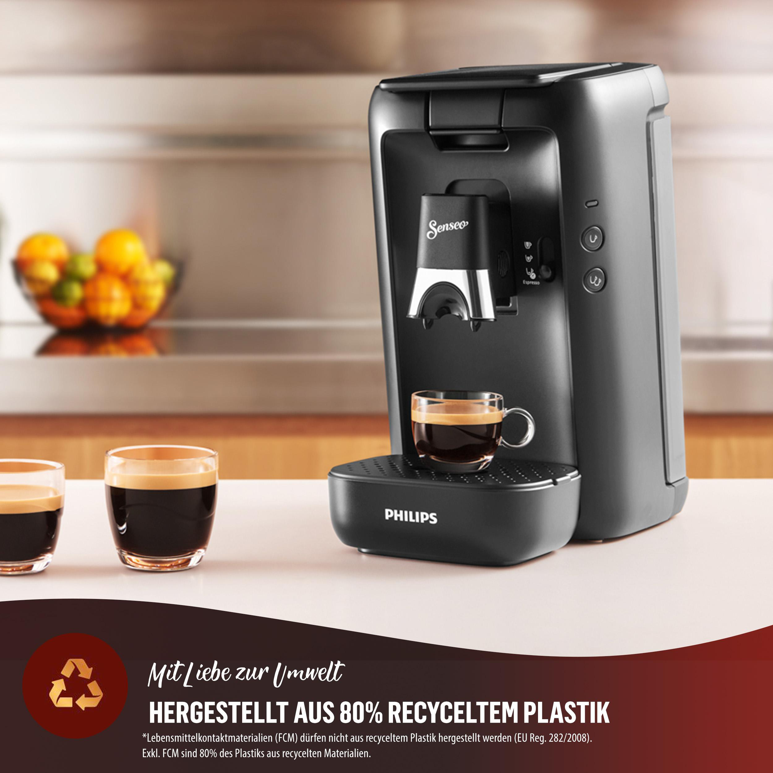 Schwarze Senseo Kaffeemaschine mit zwei Tassen auf einem Tisch in einer Küche.