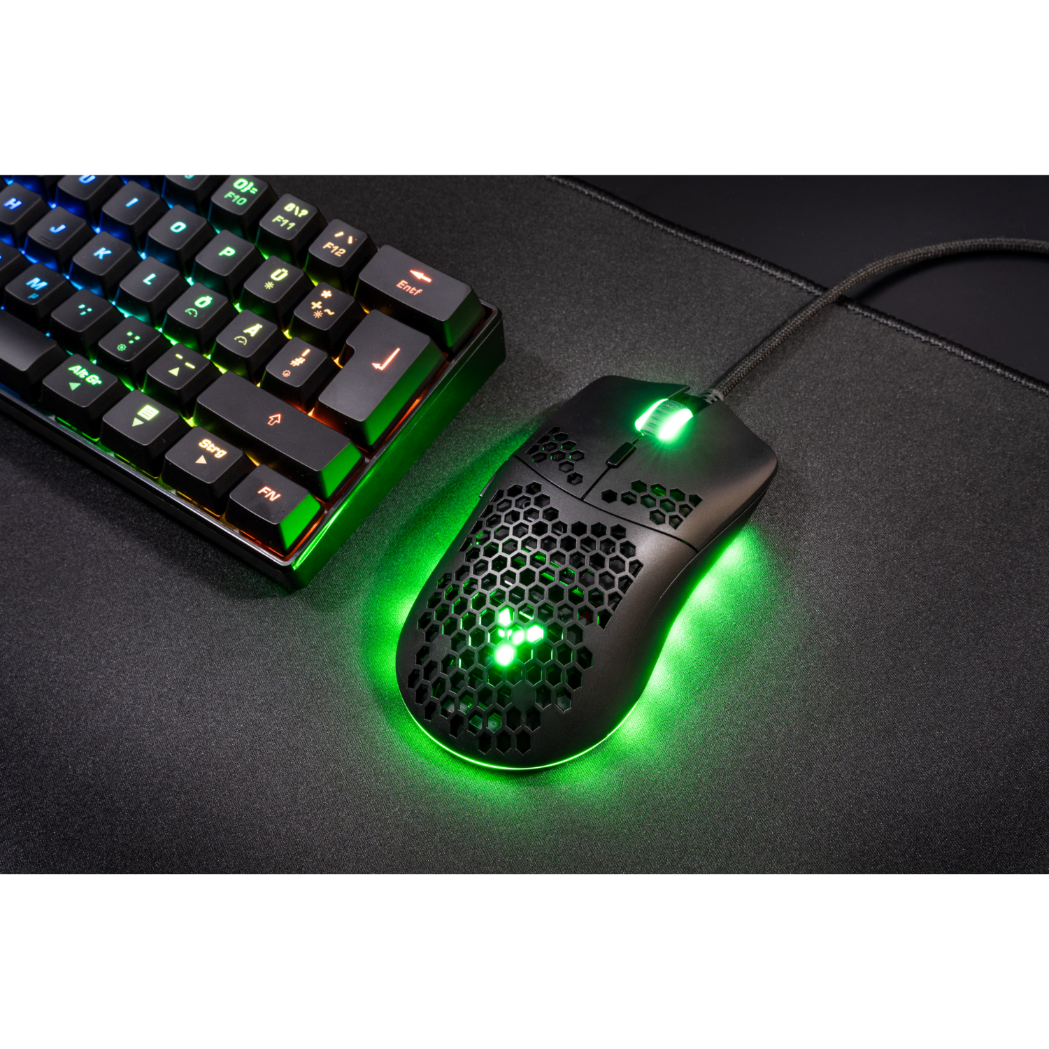 Black gaming mouse and a keyboard. The mouse is lit with a green glow.