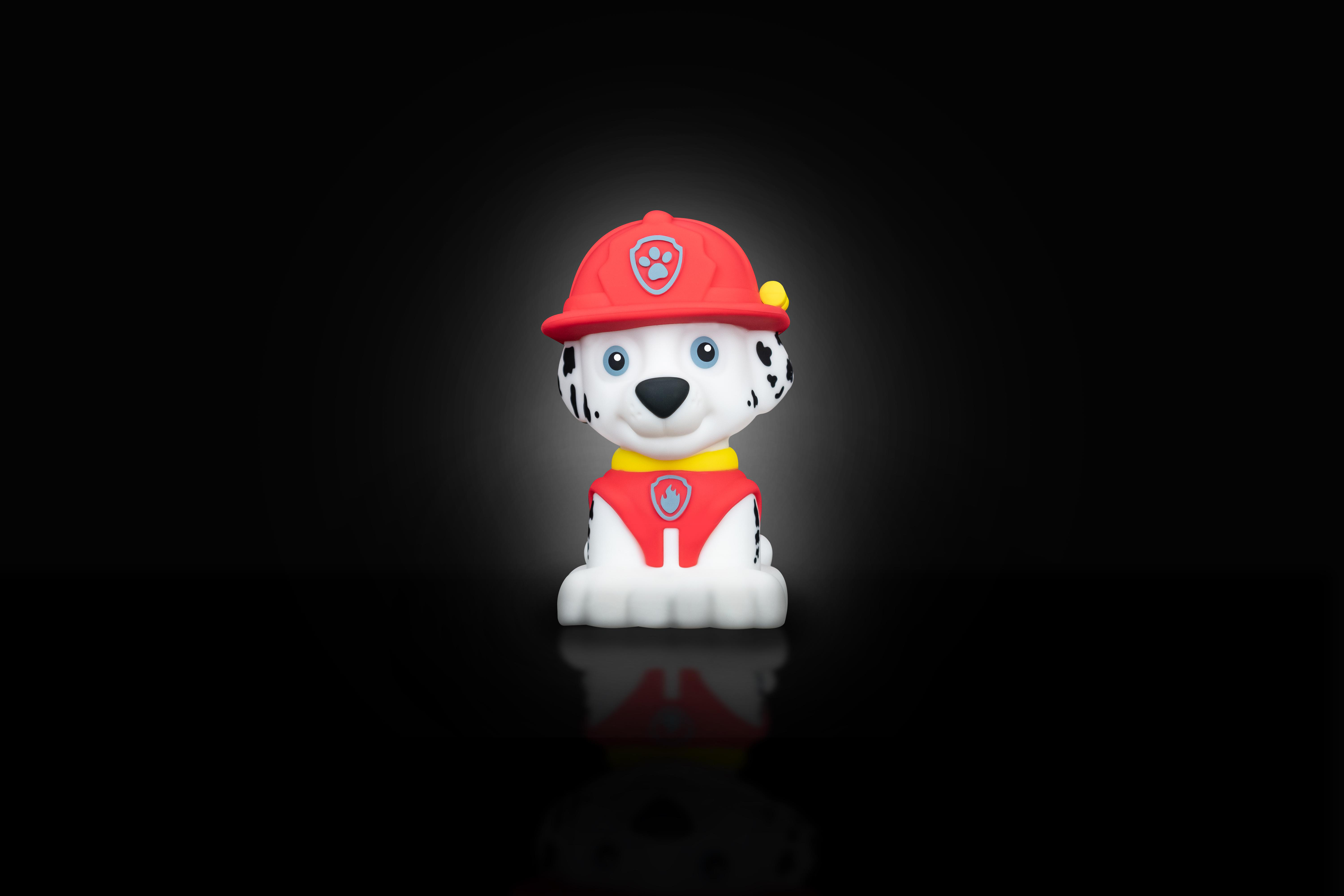 Paw Patrol Marshall Spielzeug auf schwarzer Oberfläche. Das Spielzeug ist rot und weiß, und reflektiert.
