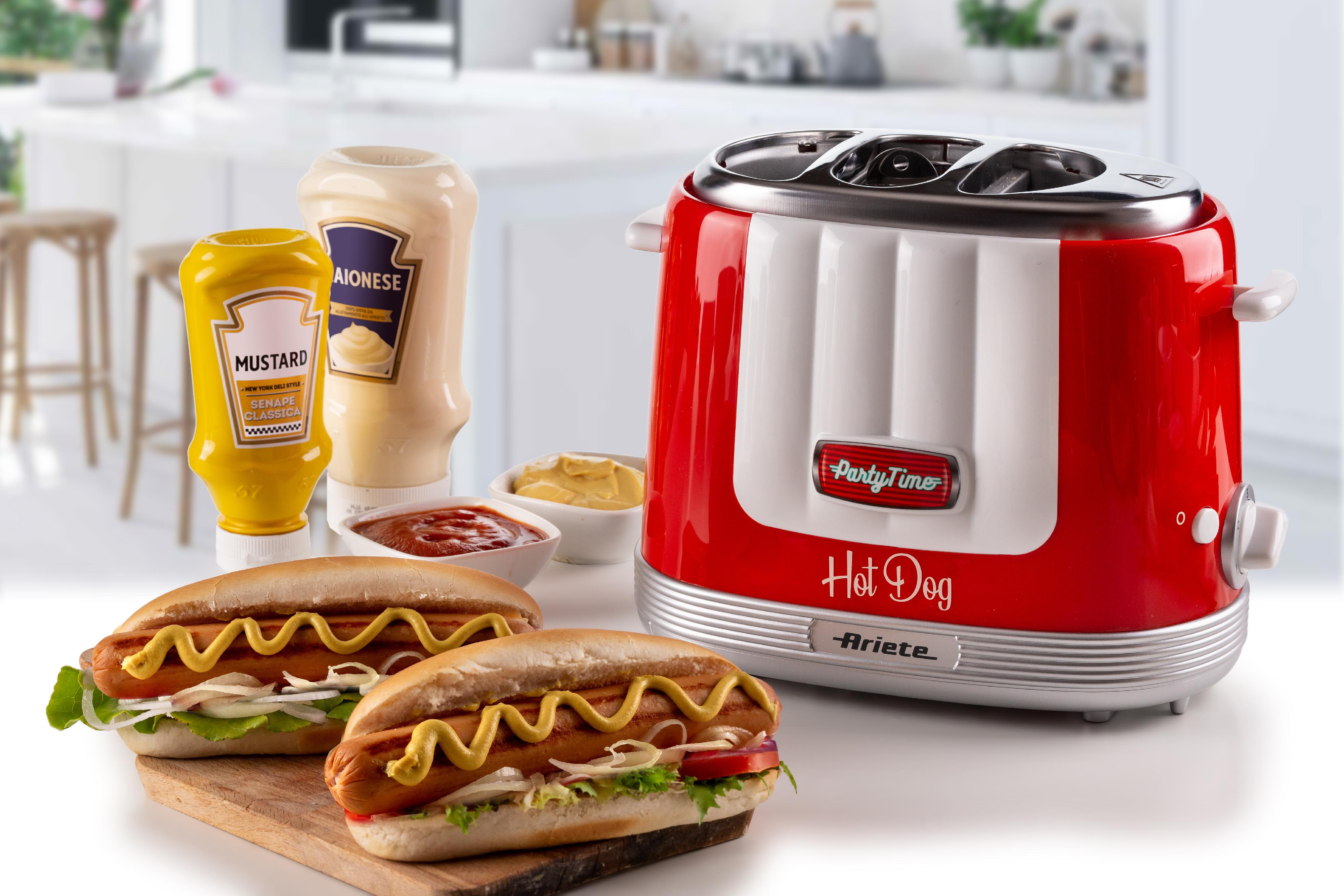 Zwei Hotdogs auf einem Schneidebrett neben einem rot-weißen Hotdog-Toaster.