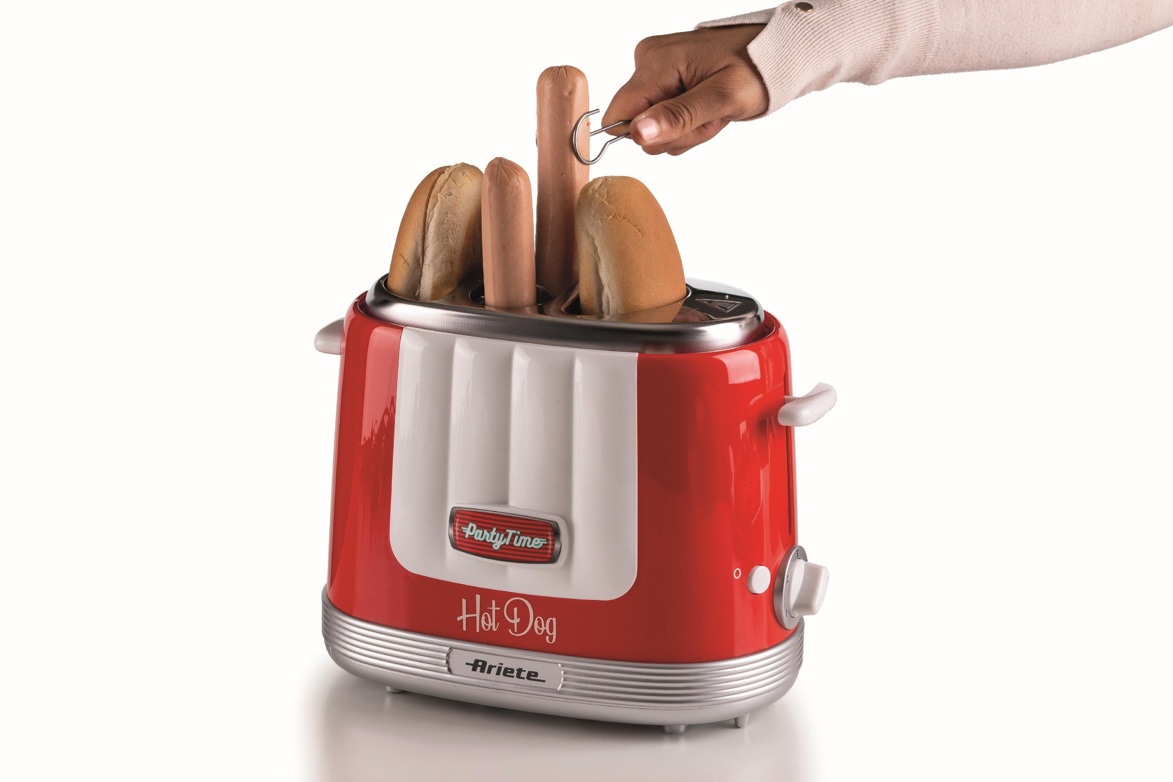 Roter Hotdog-Toaster mit Würstchen und Brötchen, Hand benutzt eine Zange.