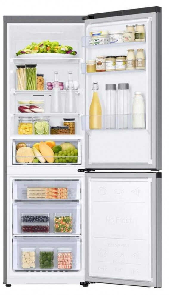 Lodówka z otwartymi drzwiami, wypełniona żywnością w szufladach i na półkach. Zawiera owoce, warzywa i pojemniki.