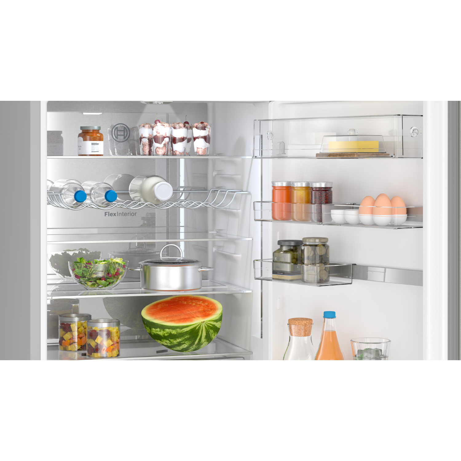 Open refrigerator filled with food items including fruit, drinks, and jars.