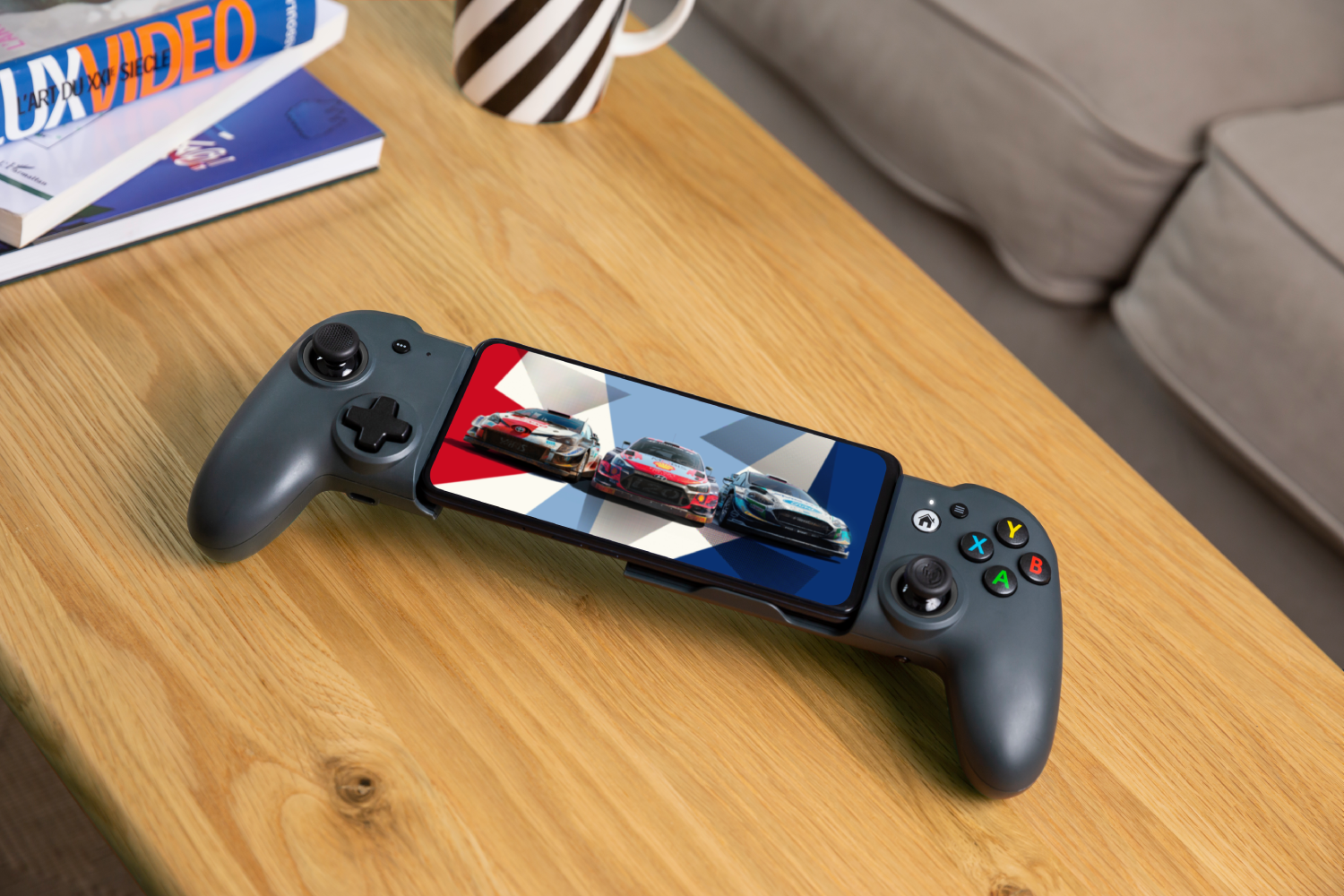 Un smartphone en un gamepad gris. La pantalla muestra coches de carreras.