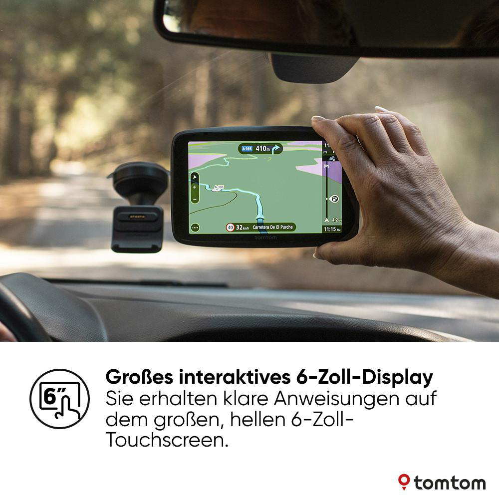 Hand, die ein GPS-Gerät hält, das eine Karte in einem Auto zeigt. Wald im Hintergrund sichtbar.