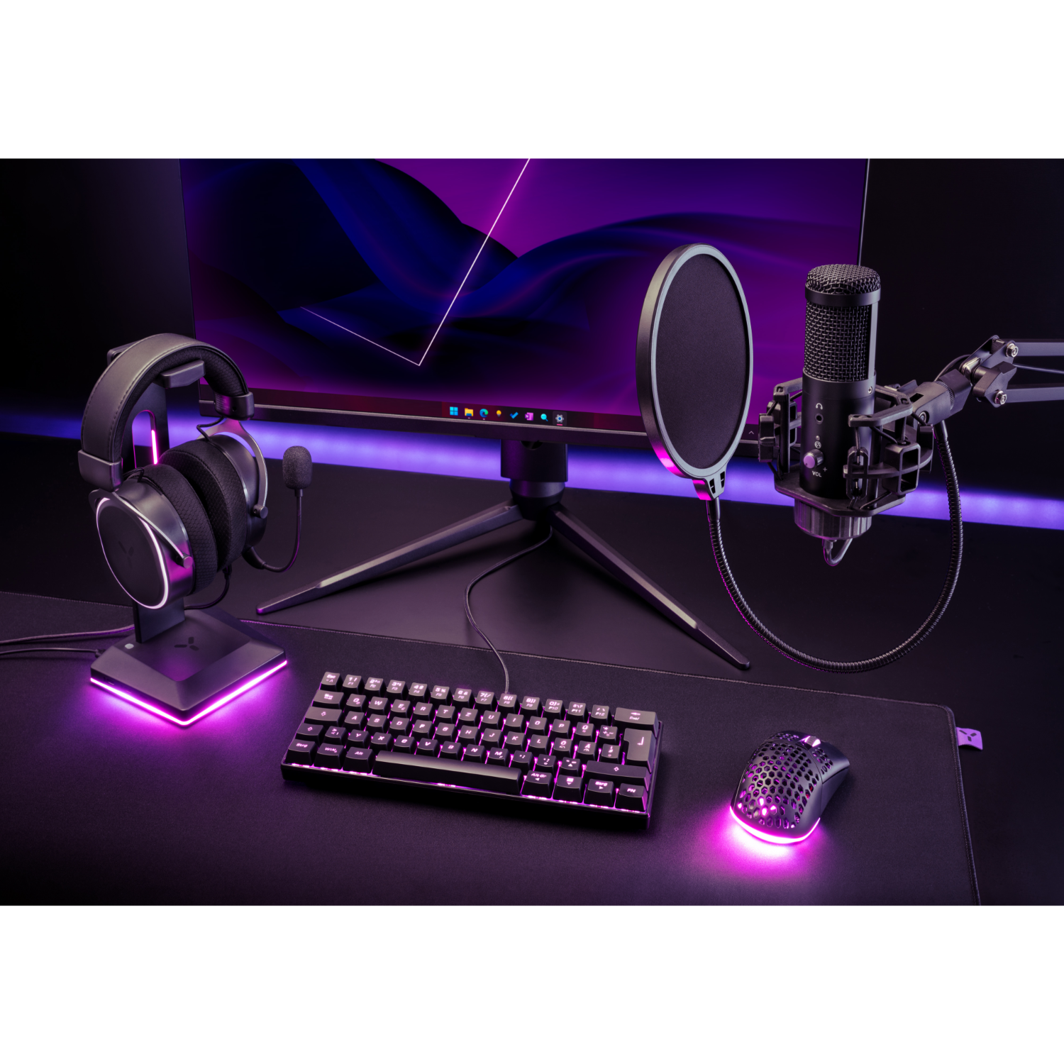 Een gaming-opstelling met een monitor, koptelefoon, toetsenbord, muis en microfoon met popfilter.