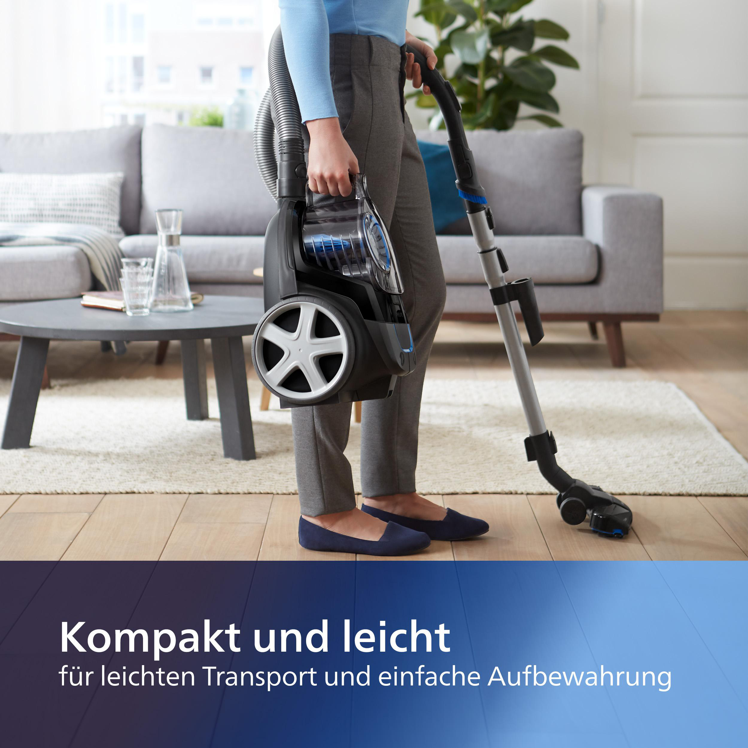 Eine Person, die einen Staubsauger trägt, in einem Wohnzimmer, Text unten.