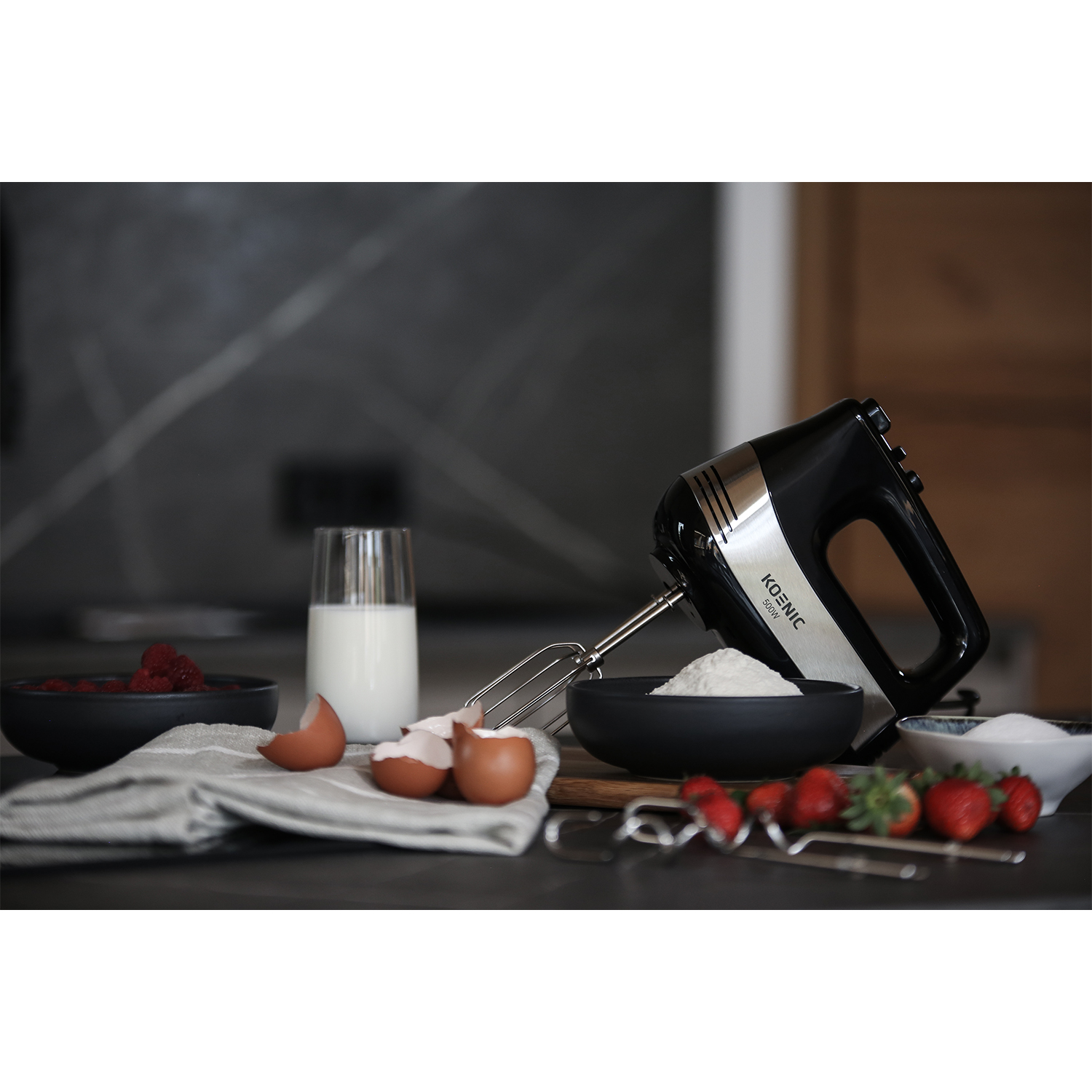 Frullatore a mano con ciotole di ingredienti. Include farina, uova, latte e fragole.