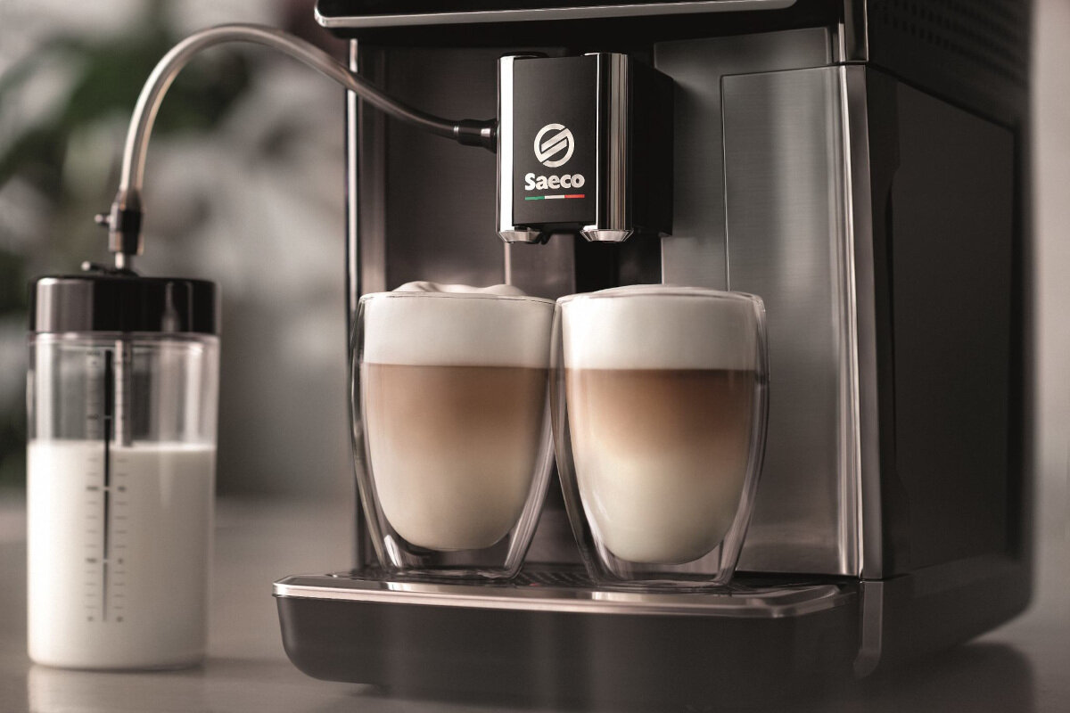 Ekspres do kawy wydaje dwie filiżanki latte macchiato.