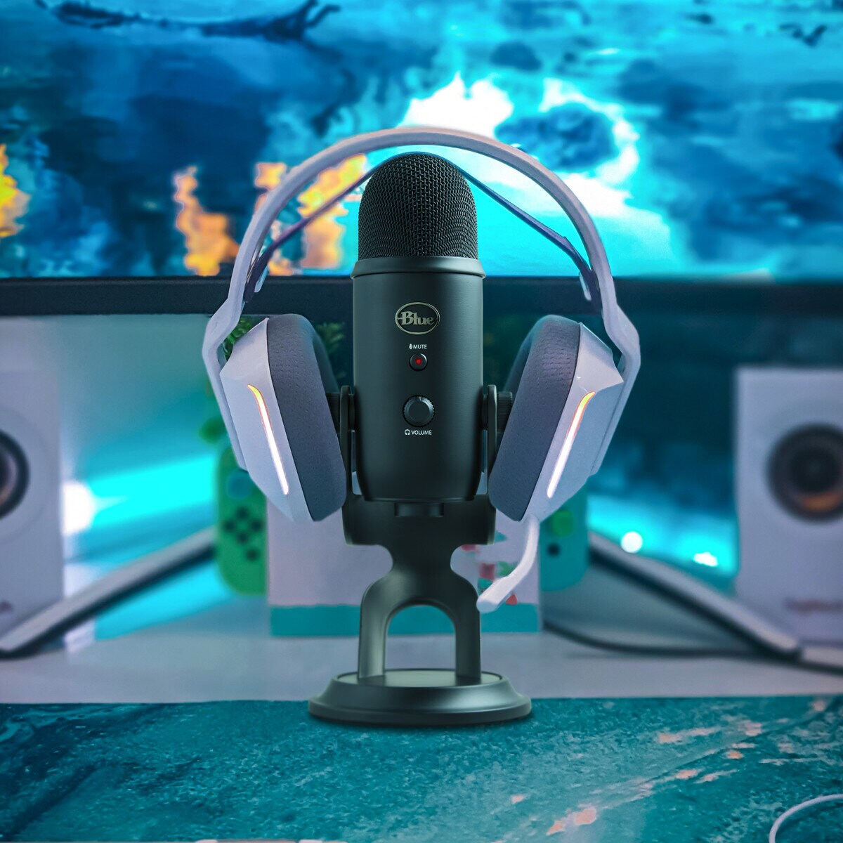 Niebieski mikrofon ze słuchawkami i stojakiem, na biurku.