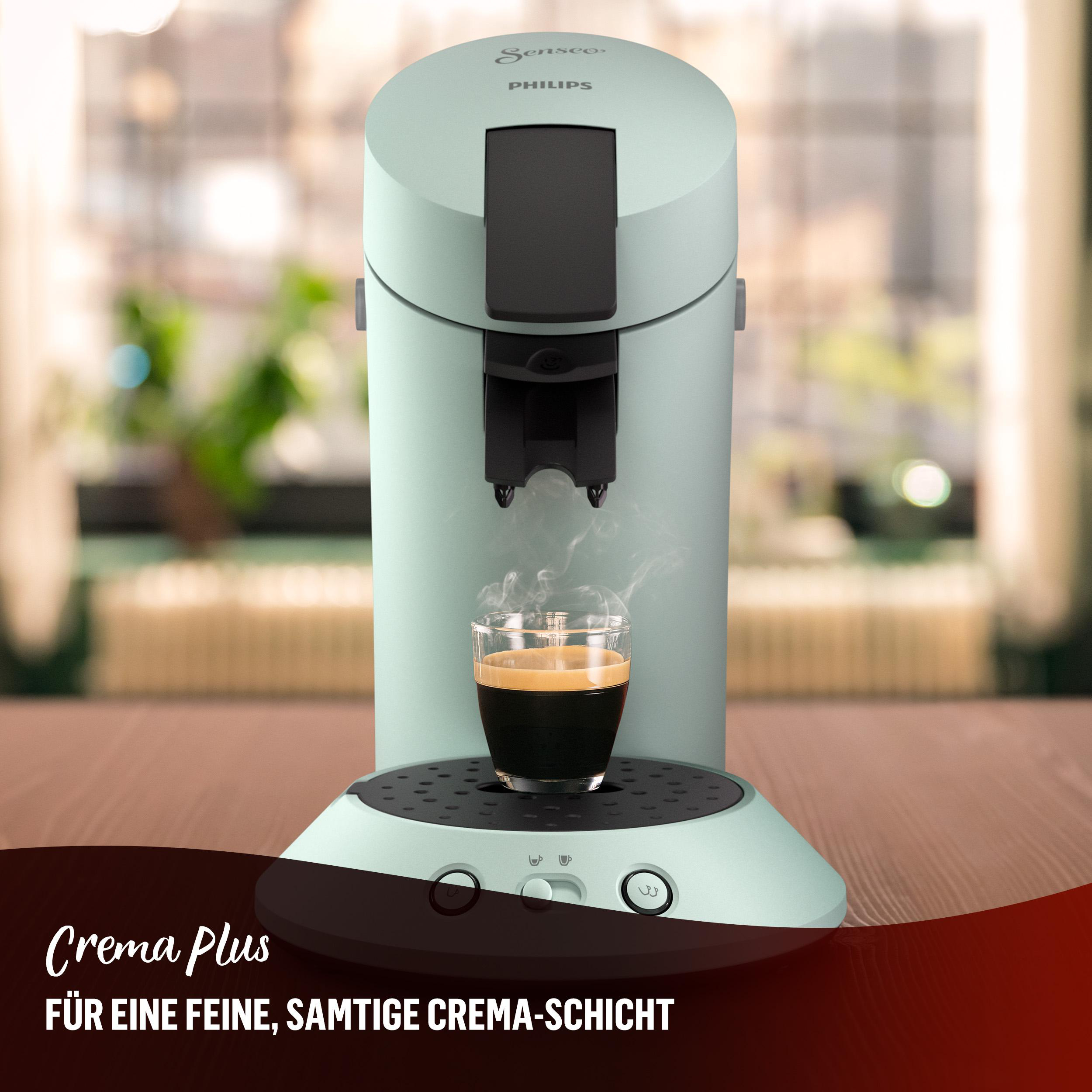 Hellgrüne Kaffeemaschine mit Kaffeeglas und Text „Crema Plus“.