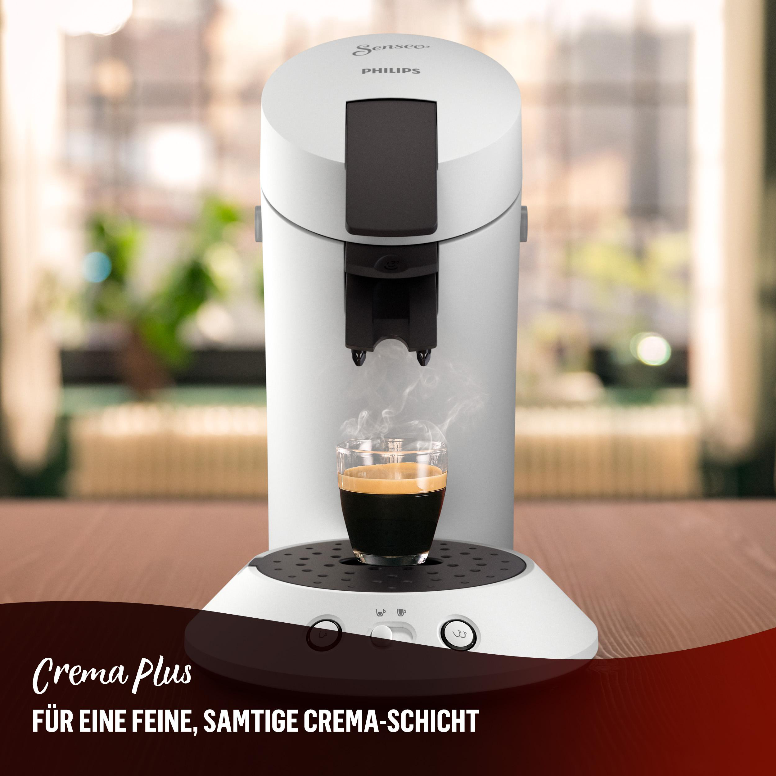 Eine weiße Philips Senseo Kaffeemaschine, die Kaffee in ein Glas ausgibt.