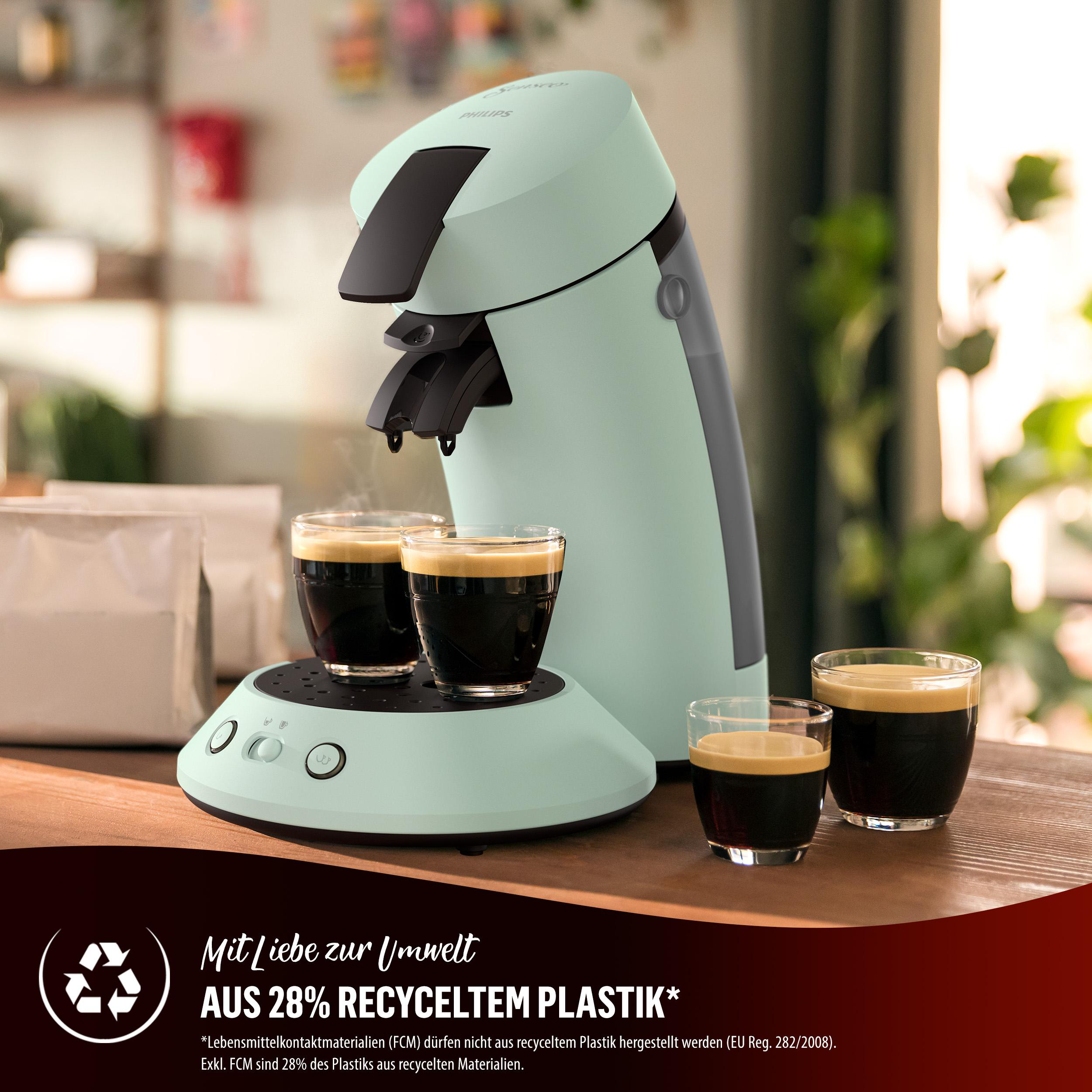 Minzgrüne Kaffeemaschine mit zwei Kaffeegläsern. Text auf der Maschine erwähnt 28 % recycelten Kunststoff.
