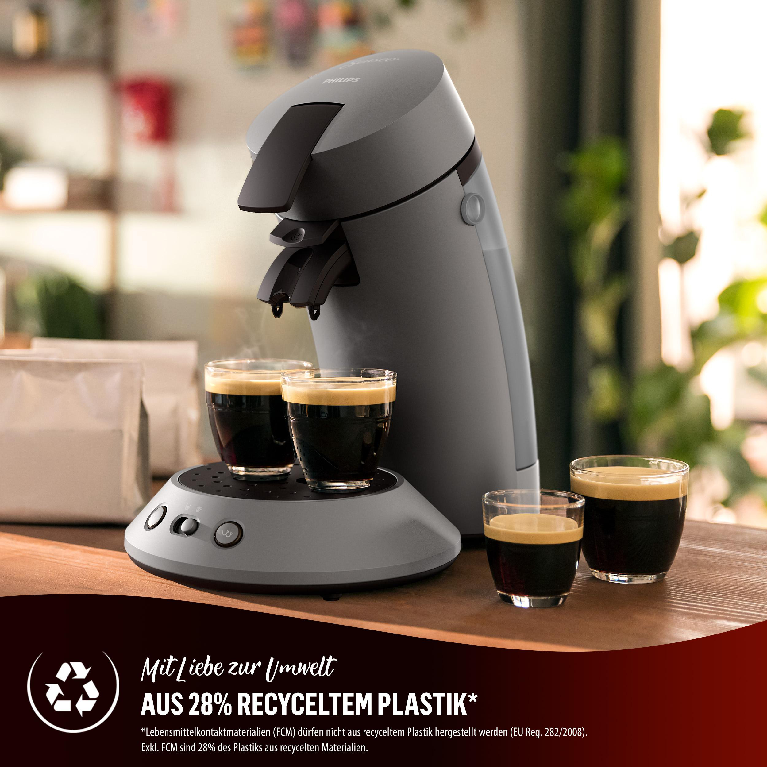 Kaffeemaschine mit Kaffeetassen und zwei gefüllten Kaffeetassen. Brauner Hintergrund.