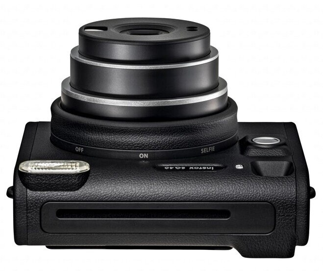 Czarny aparat Instax widziany z góry, pokazujący obiektyw, lampę błyskową i przyciski.