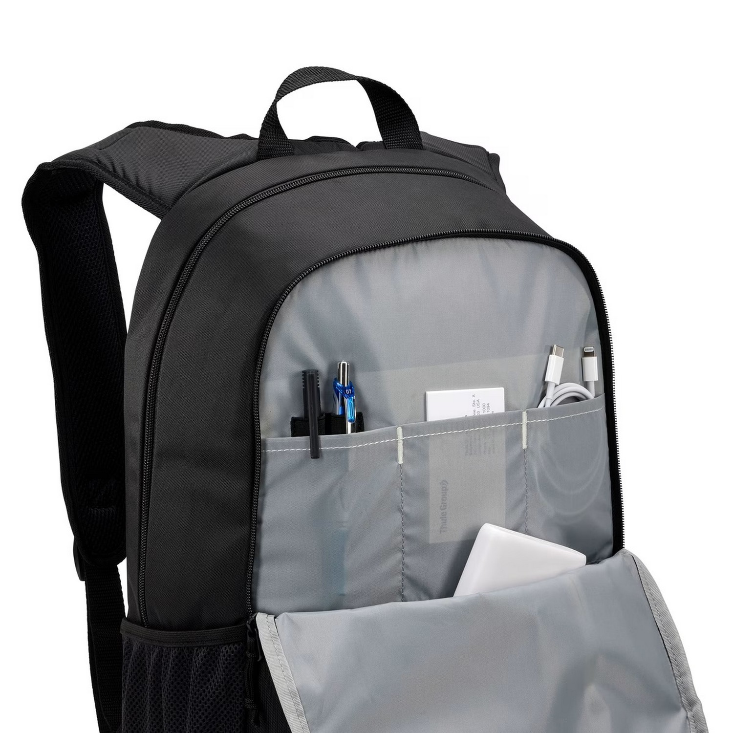 Black backpack open, showing pens, charger, phone and other items.
