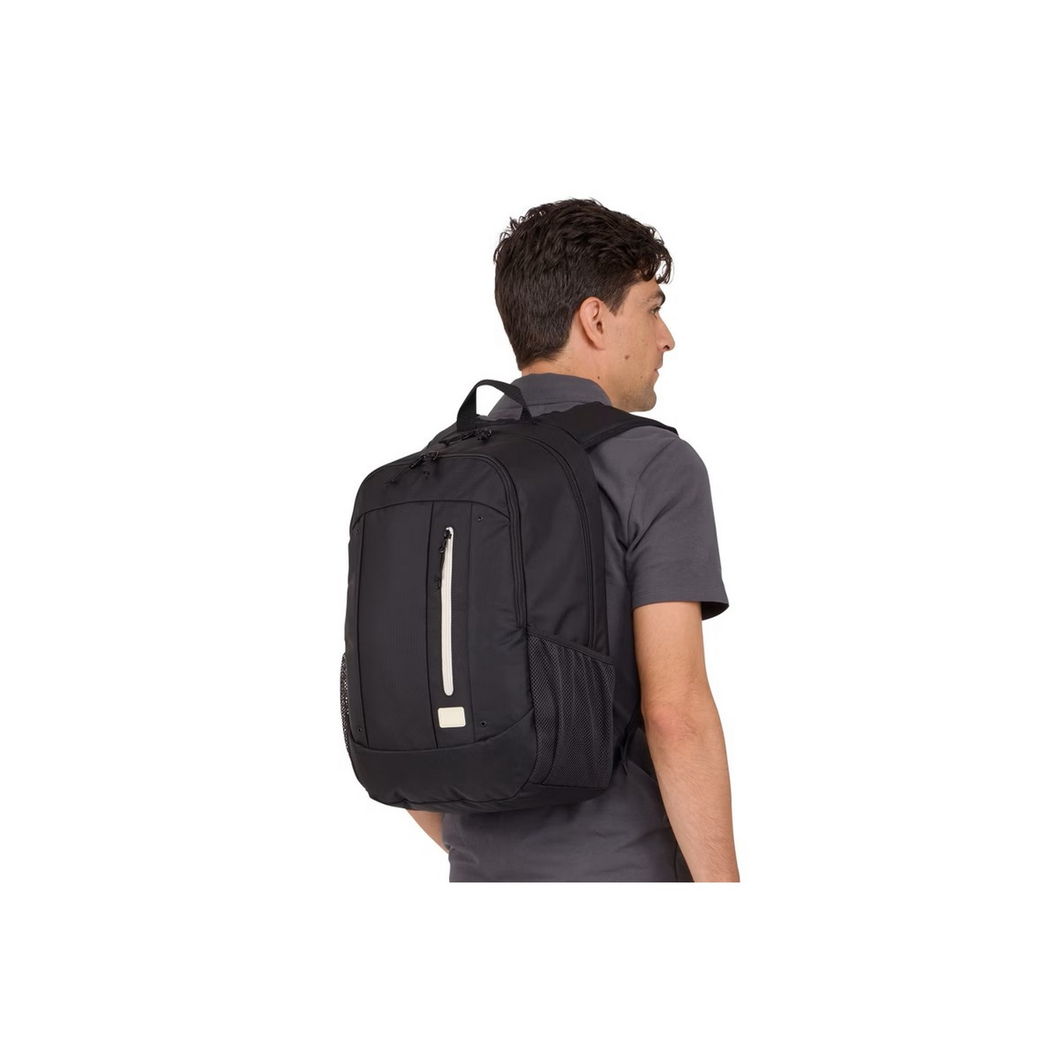 Man wearing a black backpack. He is standing, facing away from the camera.