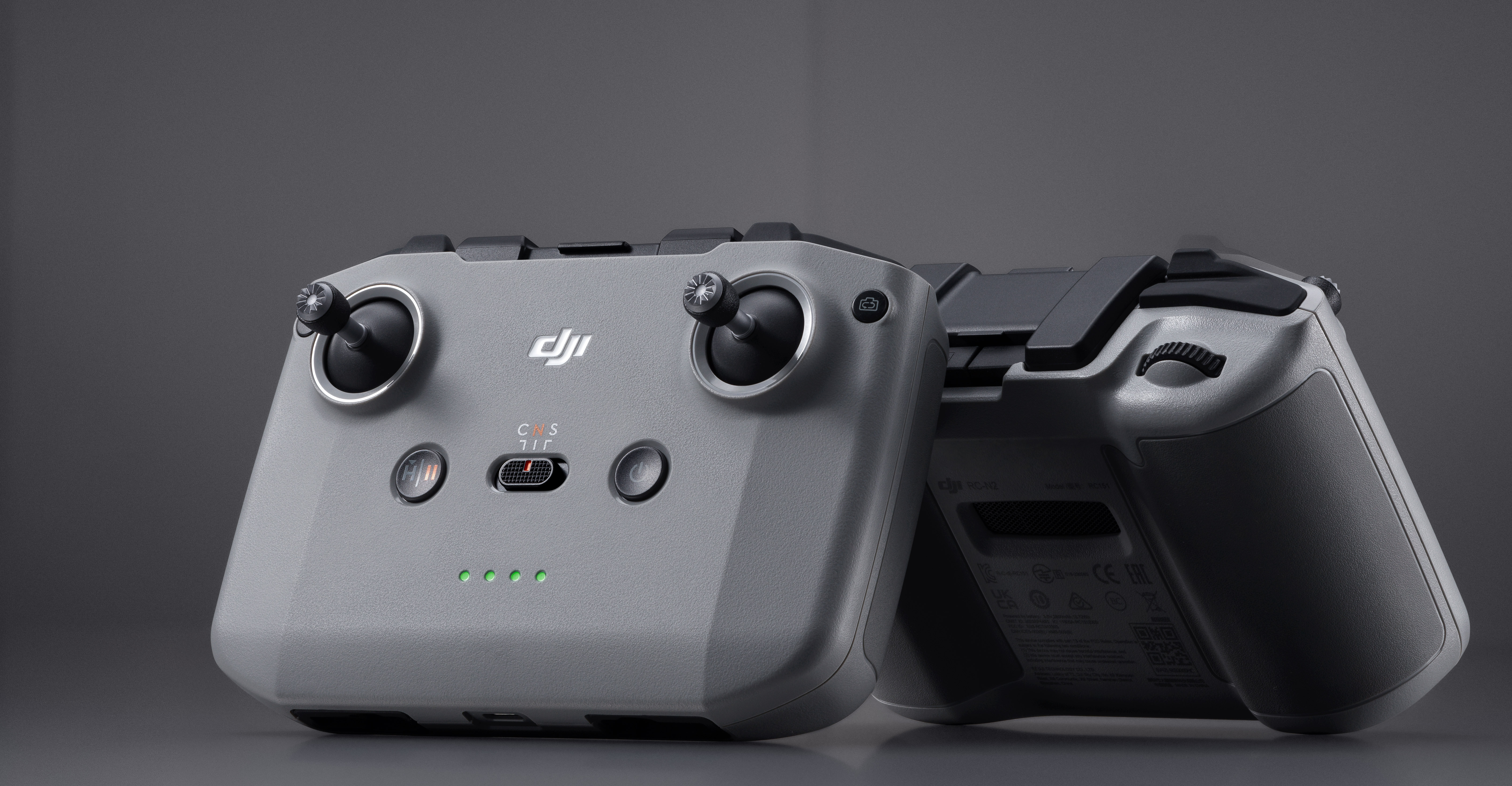 Due controller per droni DJI grigi, uno rivolto verso la fotocamera e l'altro dal retro.