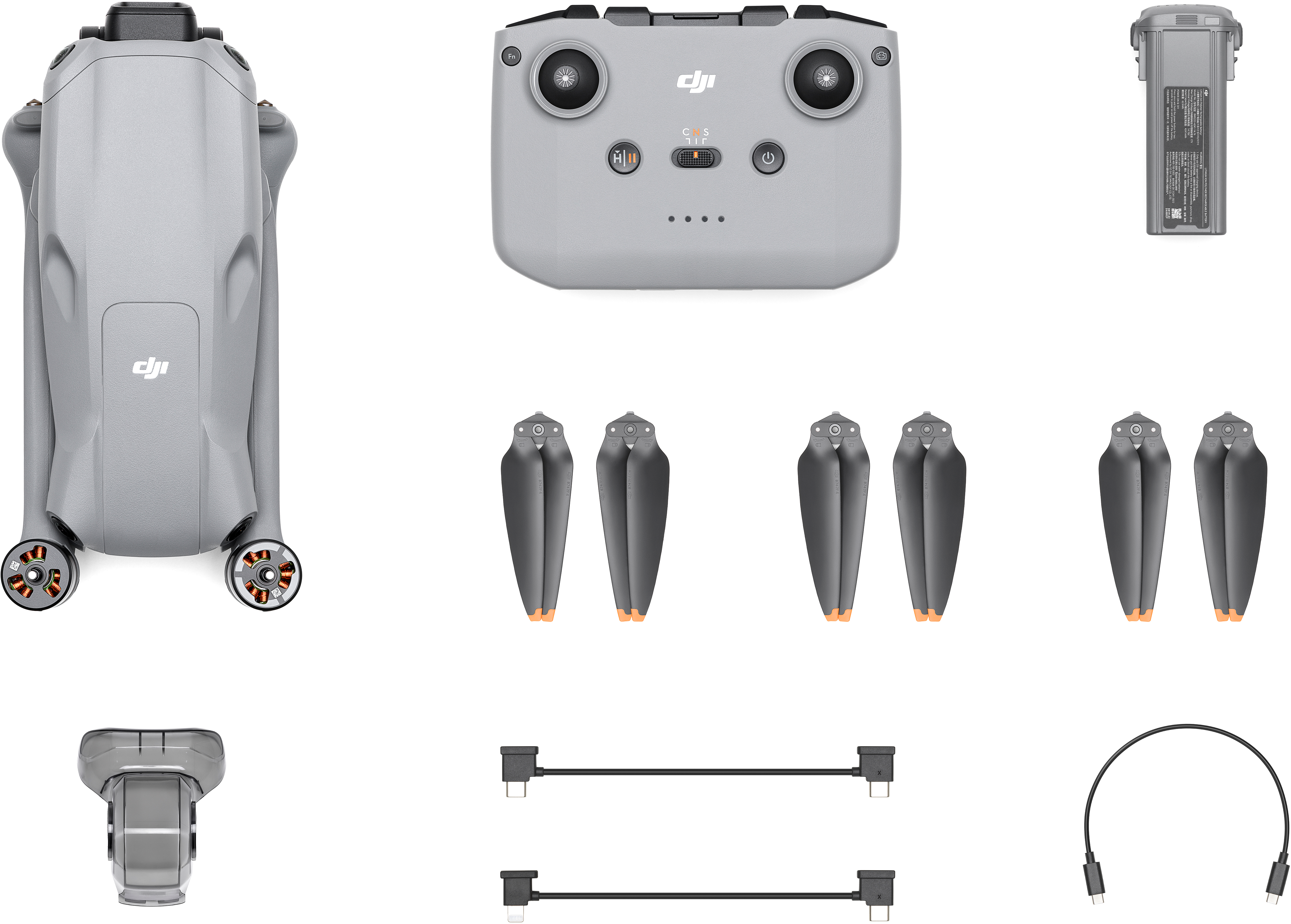 Un kit drone con drone, telecomando, batteria, eliche e cavi di ricarica.