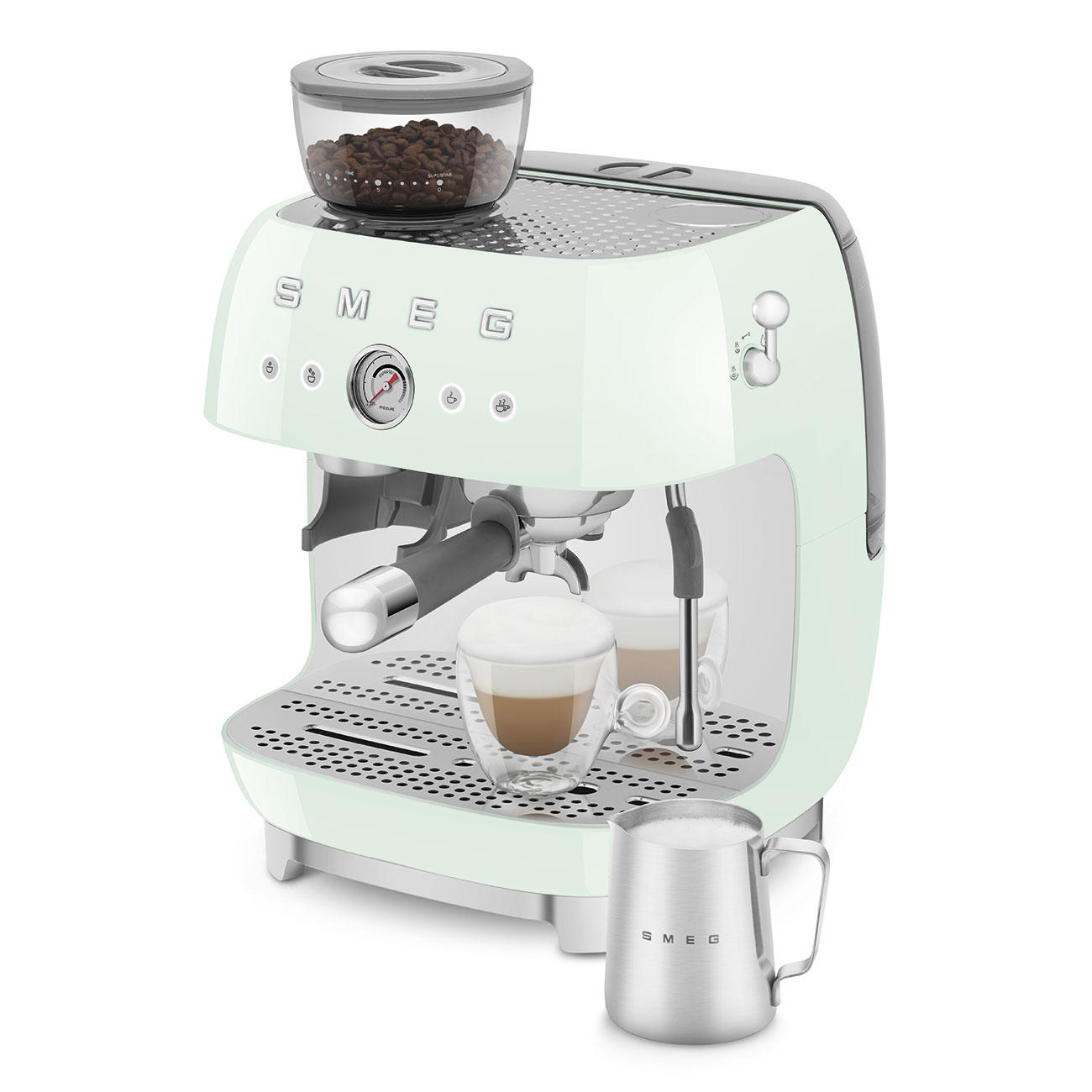 Minzgrüne Espressomaschine, Kaffeebohnenbehälter, Kaffeetassen und Milchkanne.