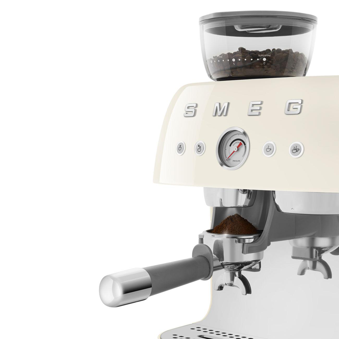 Cremefarbene SMEG Espressomaschine mit Kaffeebohnen und gemahlenem Kaffee.