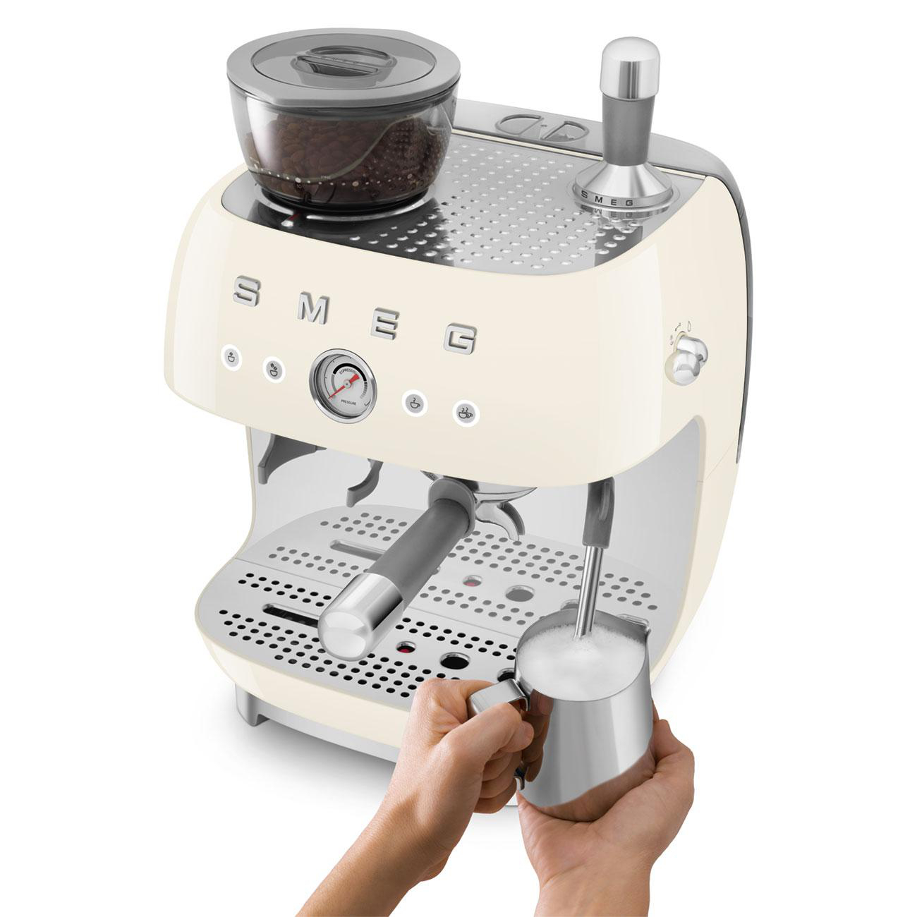 Cremefarbene Espressomaschine. Eine Hand hält eine Milchaufschäumpistole.