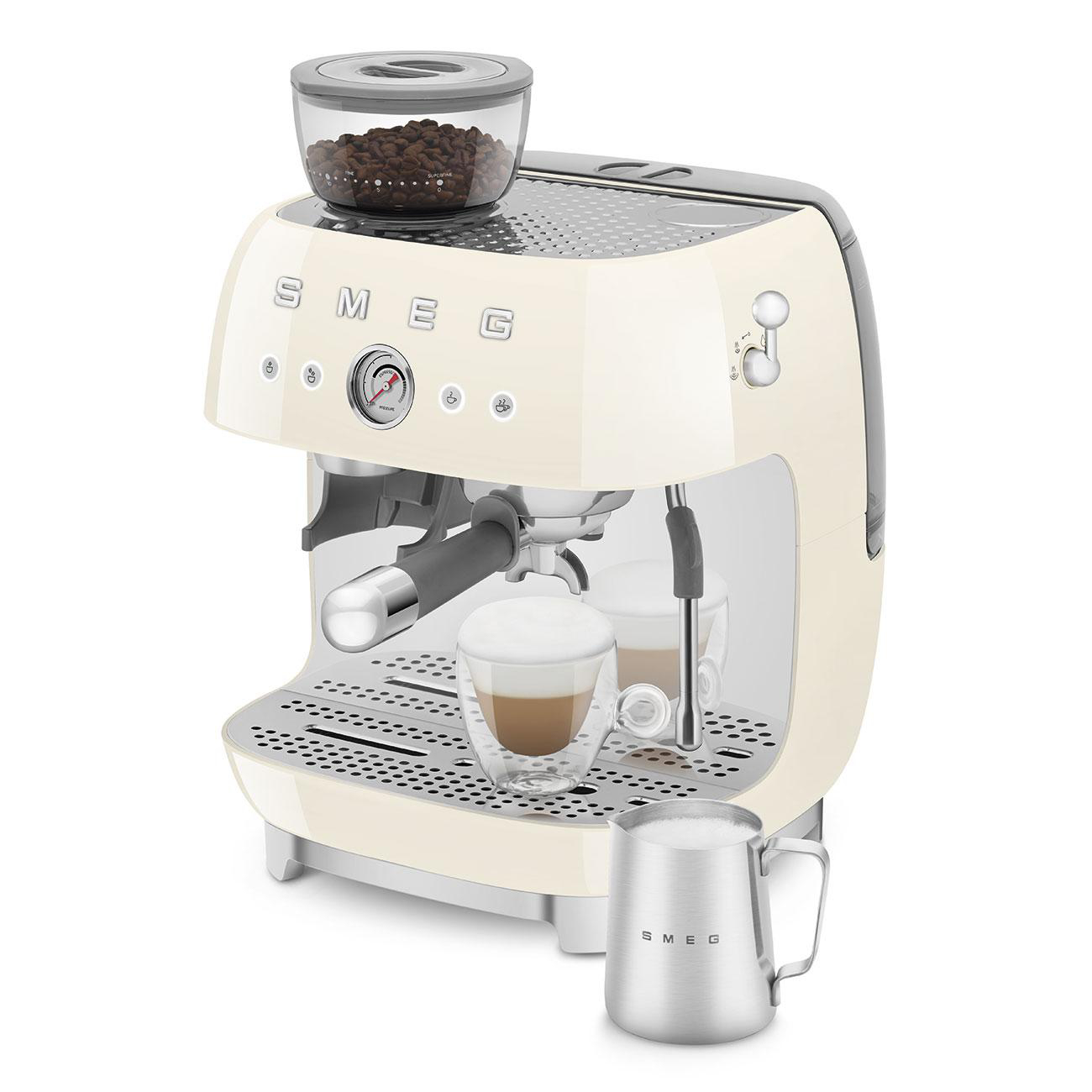 Eine cremefarbene Smeg Espressomaschine mit Kaffeebohnenbehälter, 2 Gläsern und einem Milchaufschäumer.