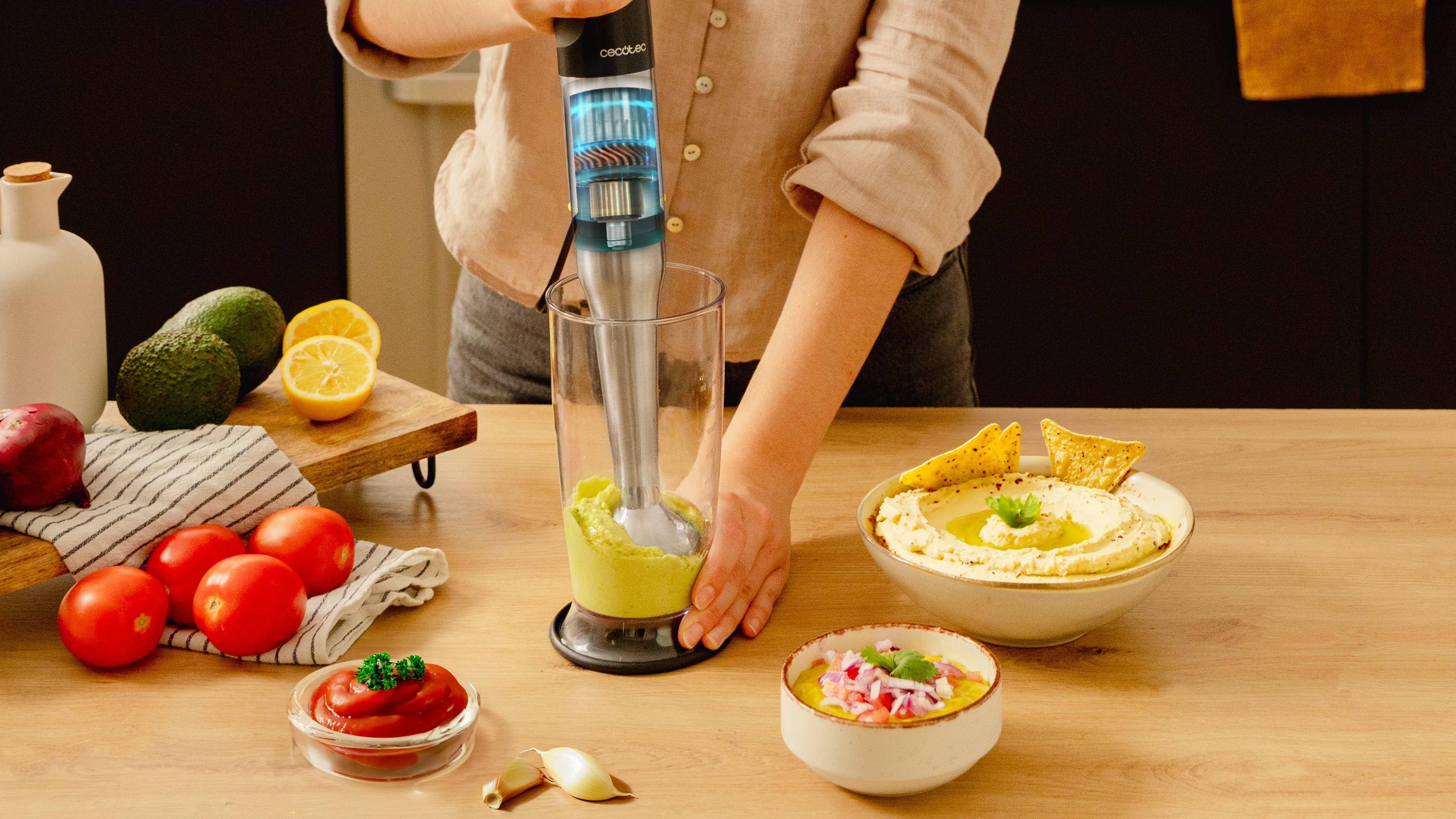 Persona mezclando ingredientes para hummus. Ingredientes: aguacate, tomates y hummus.
