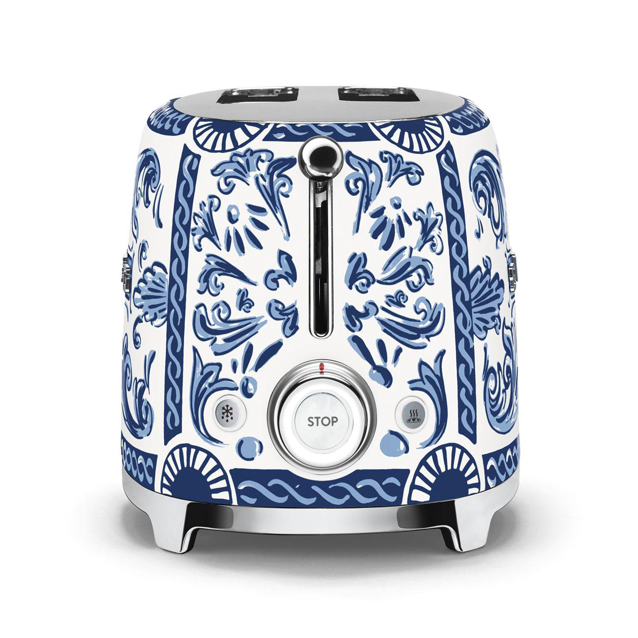 Weißer und blau gemusterter Toaster mit Metallrahmen.