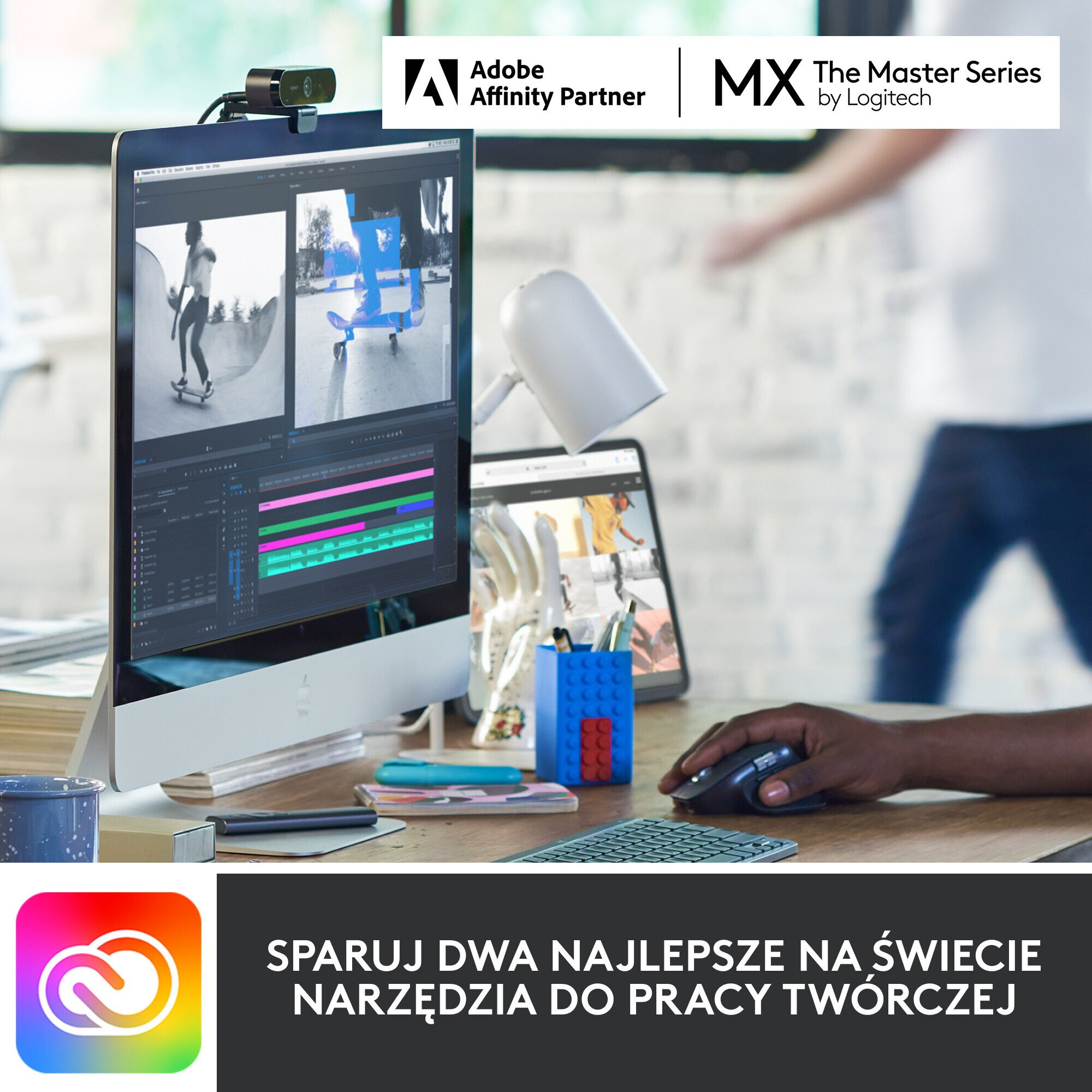 Konfiguracja biurka z komputerem, tabletem i kamerą internetową. Osoba używająca myszy. Widoczne logo Adobe i Logitech.