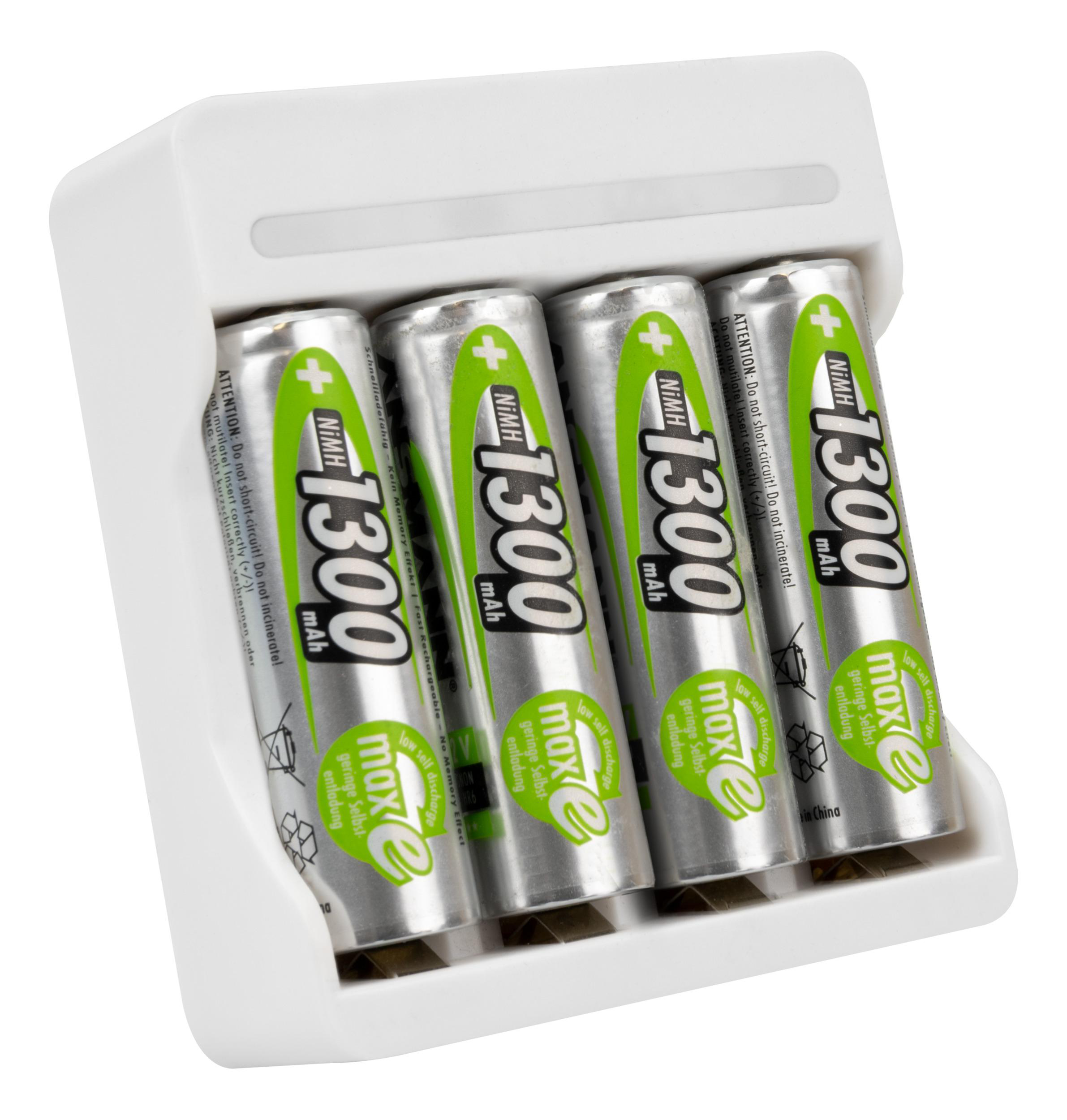 Vier AA-Batterien in einem weißen Ladegerät. Batterien sind silber, grün und schwarz. Das Ladegerät ist weiß.