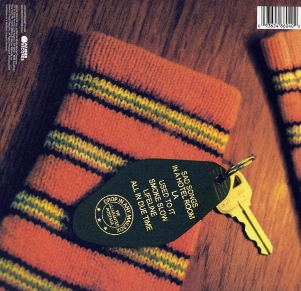 Schlüssel mit Anhänger: 'Sad Songs in a Hotel Room' auf einer gestreiften orange-gelben Socke.