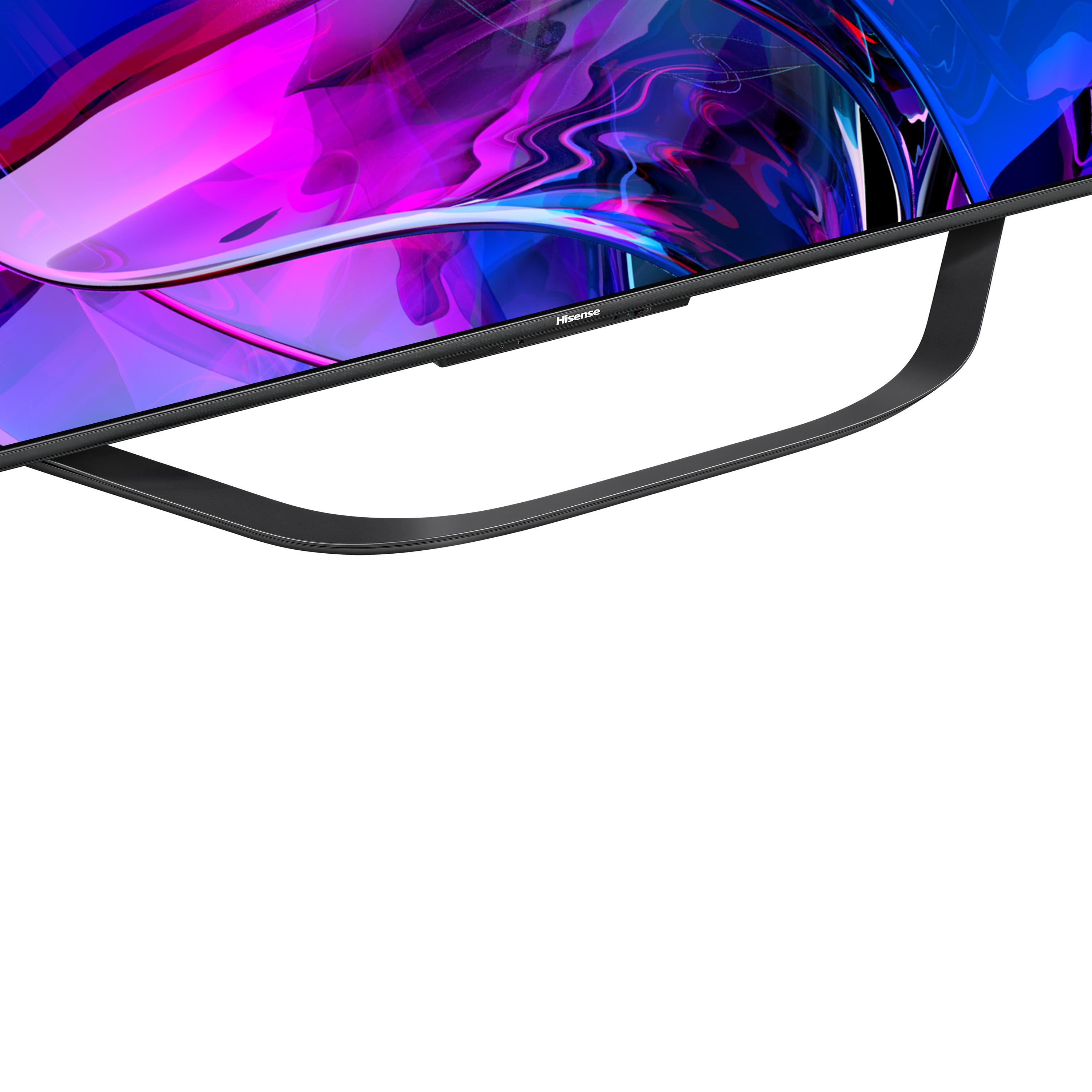 Nahaufnahme eines Hisense-Fernsehers. Mit gebogenem schwarzen Standfuß und farbenfrohem Bildschirm.
