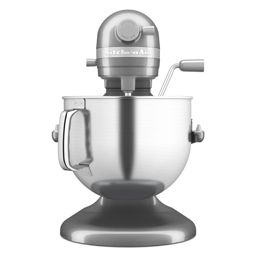 Egy ezüst KitchenAid állványos mixer, a keverőtállal, motorral és fogantyúval.