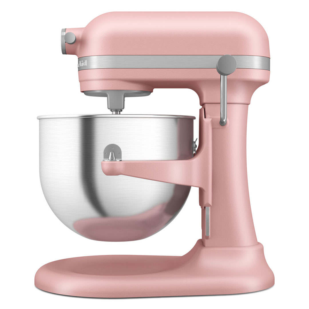 Rózsaszín KitchenAid robotgép rozsdamentes acéltállal, fehér háttér előtt.