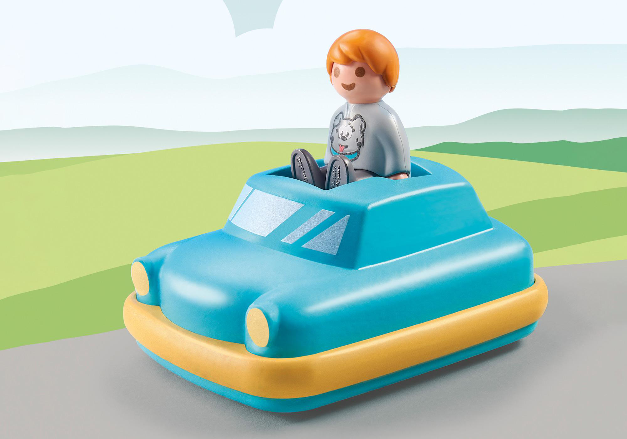 Eine Kinderfigur in einem blauen Spielzeugauto. Das Spielzeug hat eine gelbe Zierleiste.