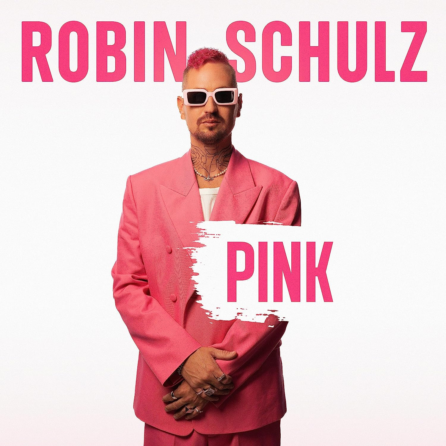 Rózsaszín öltönyös, napszemüveges férfi, rózsaszín haj, 'ROBIN SCHULZ' és 'PINK' szöveg.