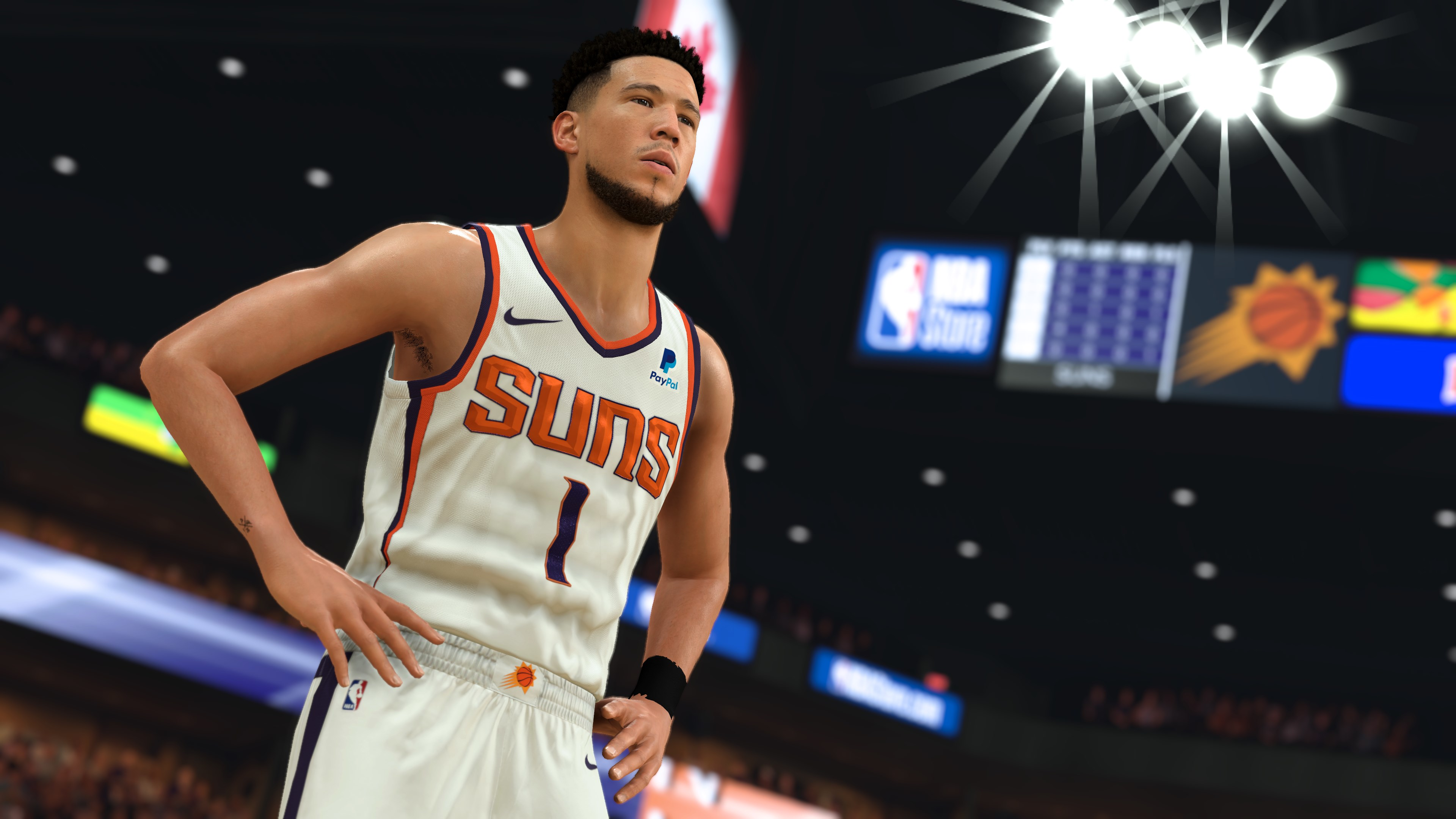 Joueur NBA en maillot blanc, dans un cadre de stade, avec le logo des Suns visible.