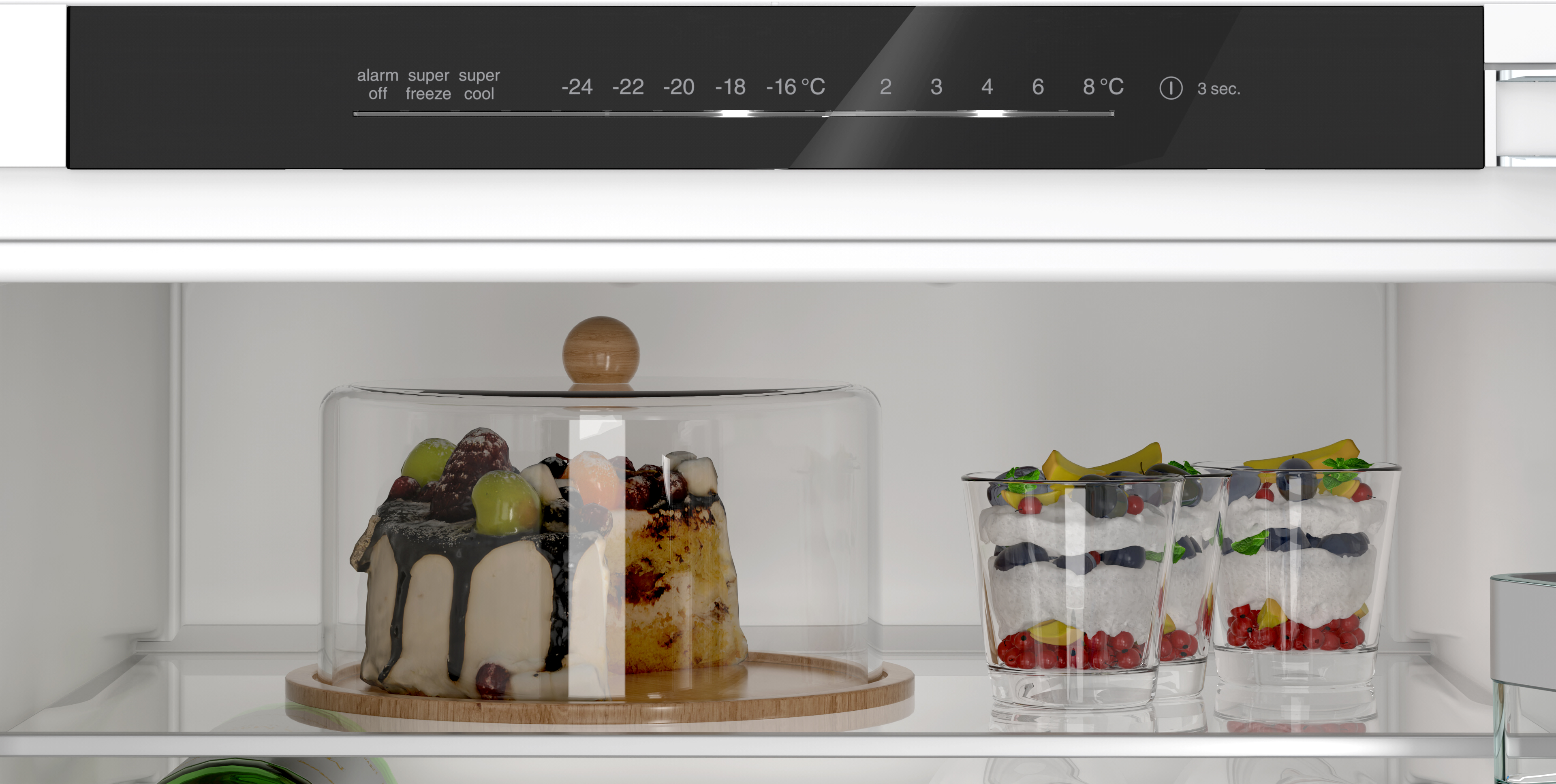Im Kühlschrank: Kuchen unter einer Glasglocke, Desserts in Gläsern und Temperaturregler oben.